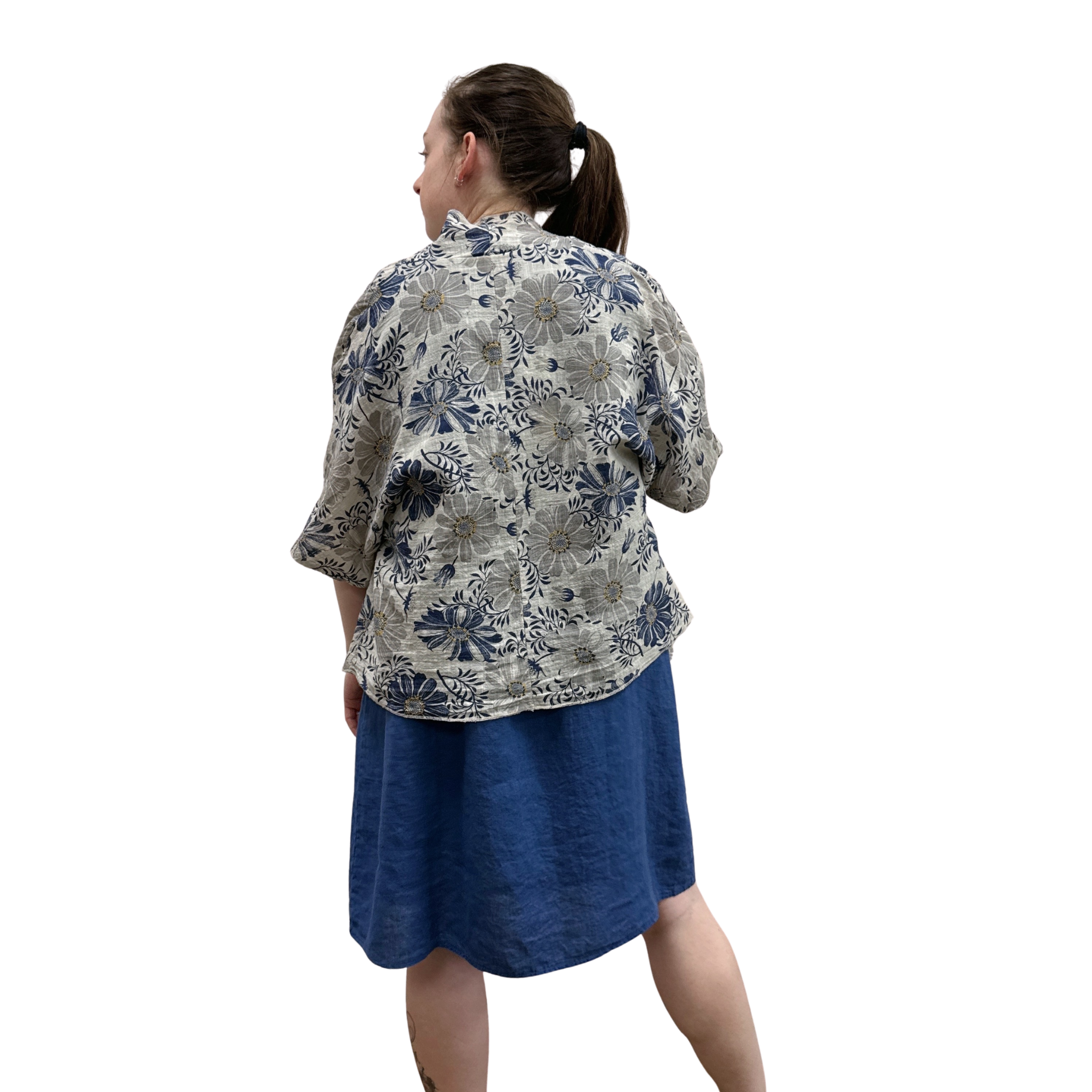 Woman wearing a floral blouse and blue skirt on a white background