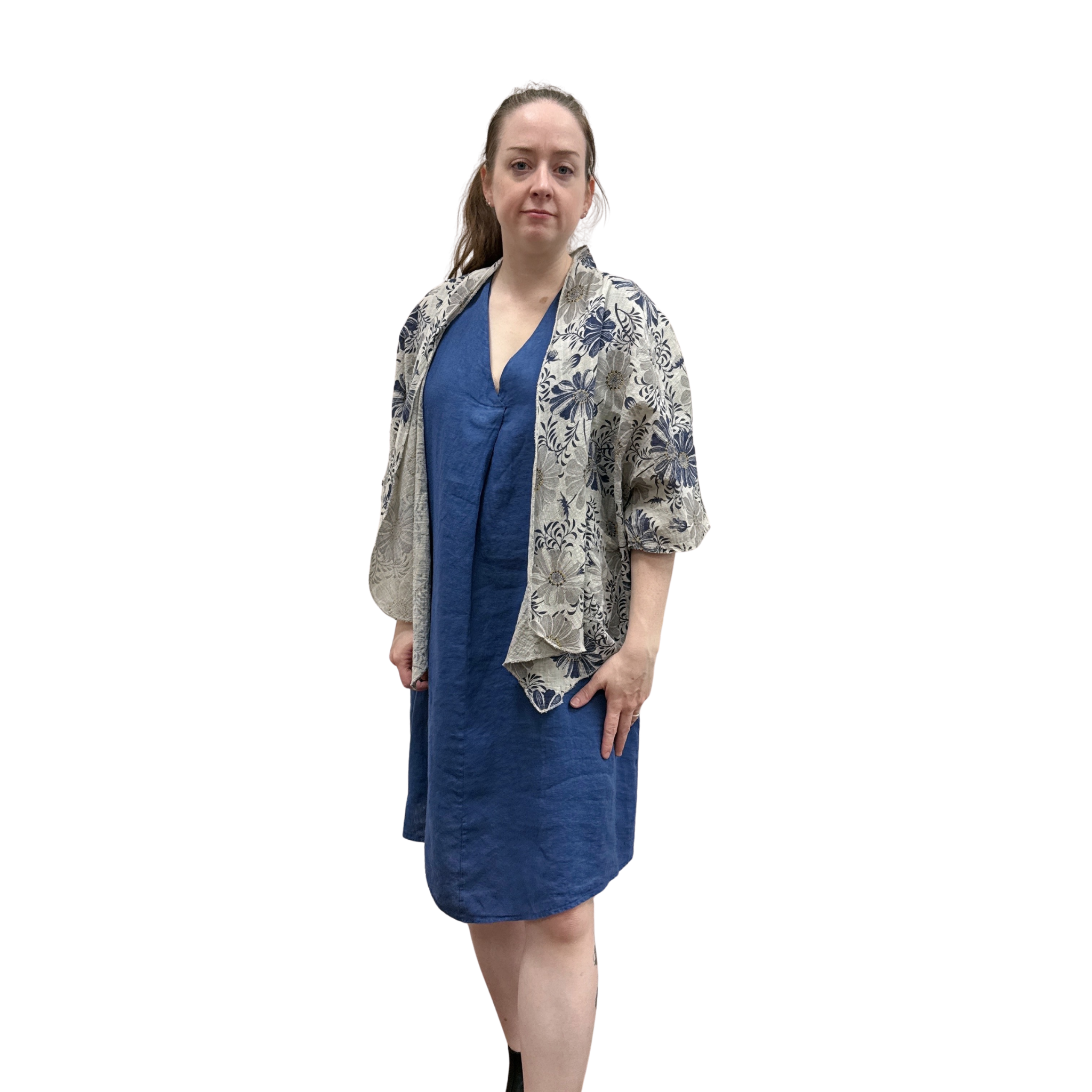 Woman wearing a blue dress and floral jacket on a white background