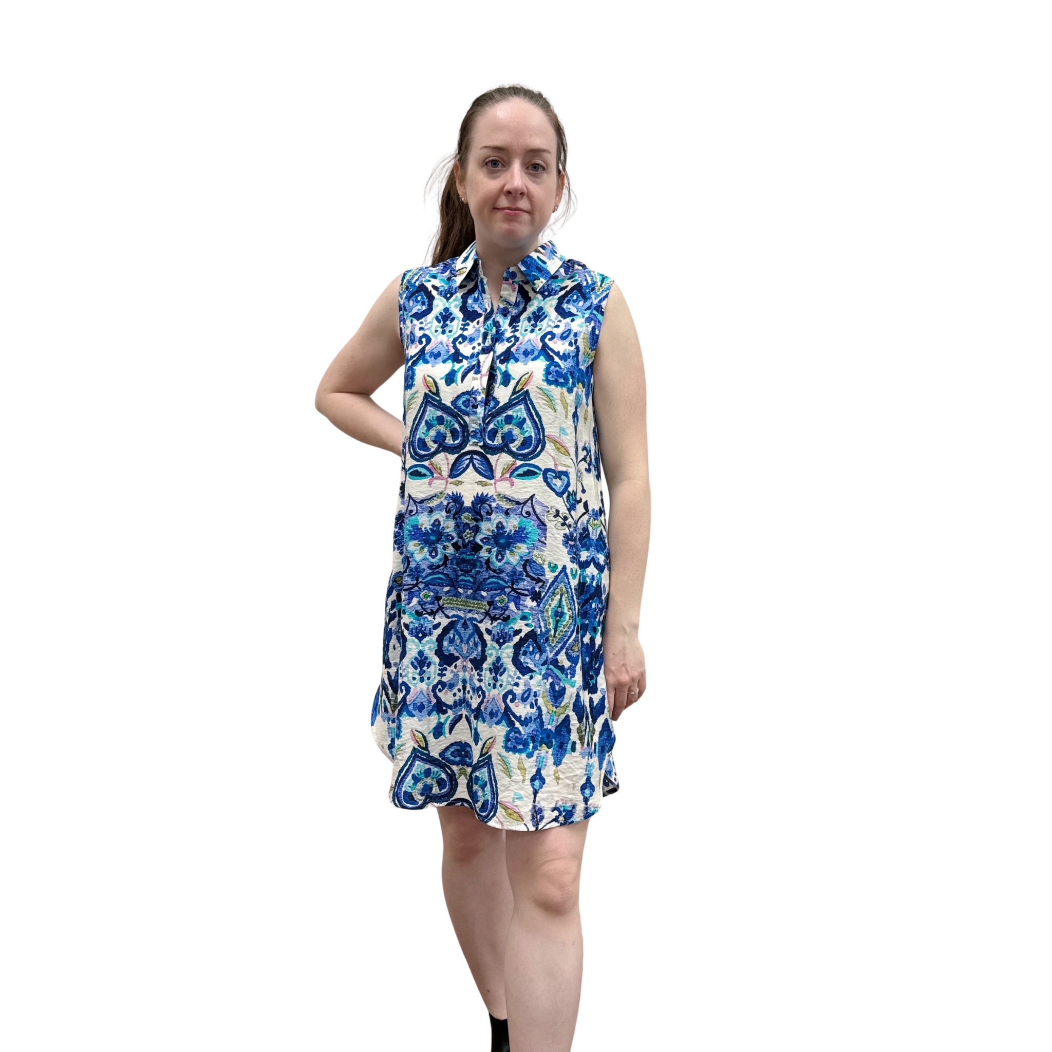 Woman wearing a sleeveless floral dress with blue and white pattern on a white background