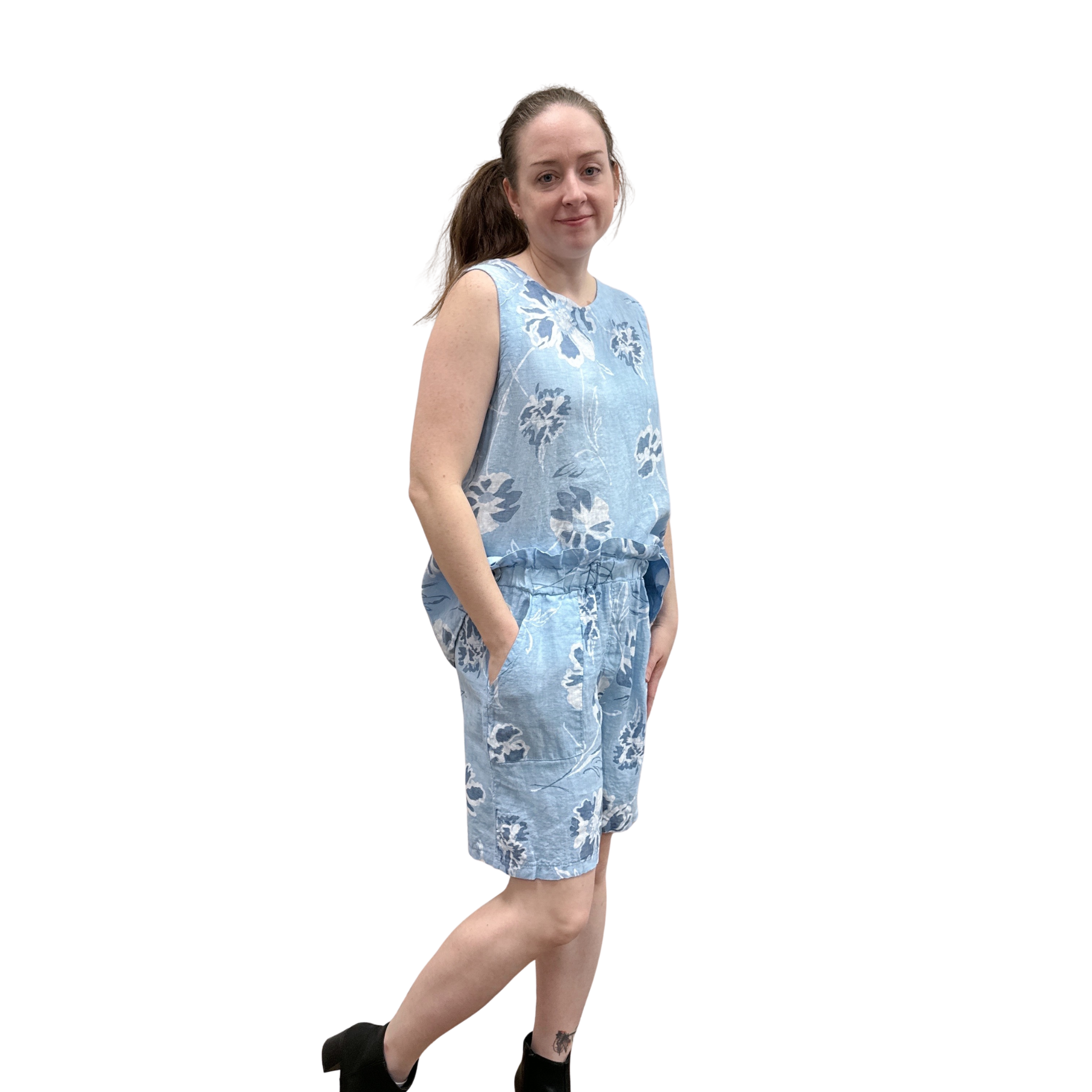 Woman wearing a blue floral tank and short set on a white background