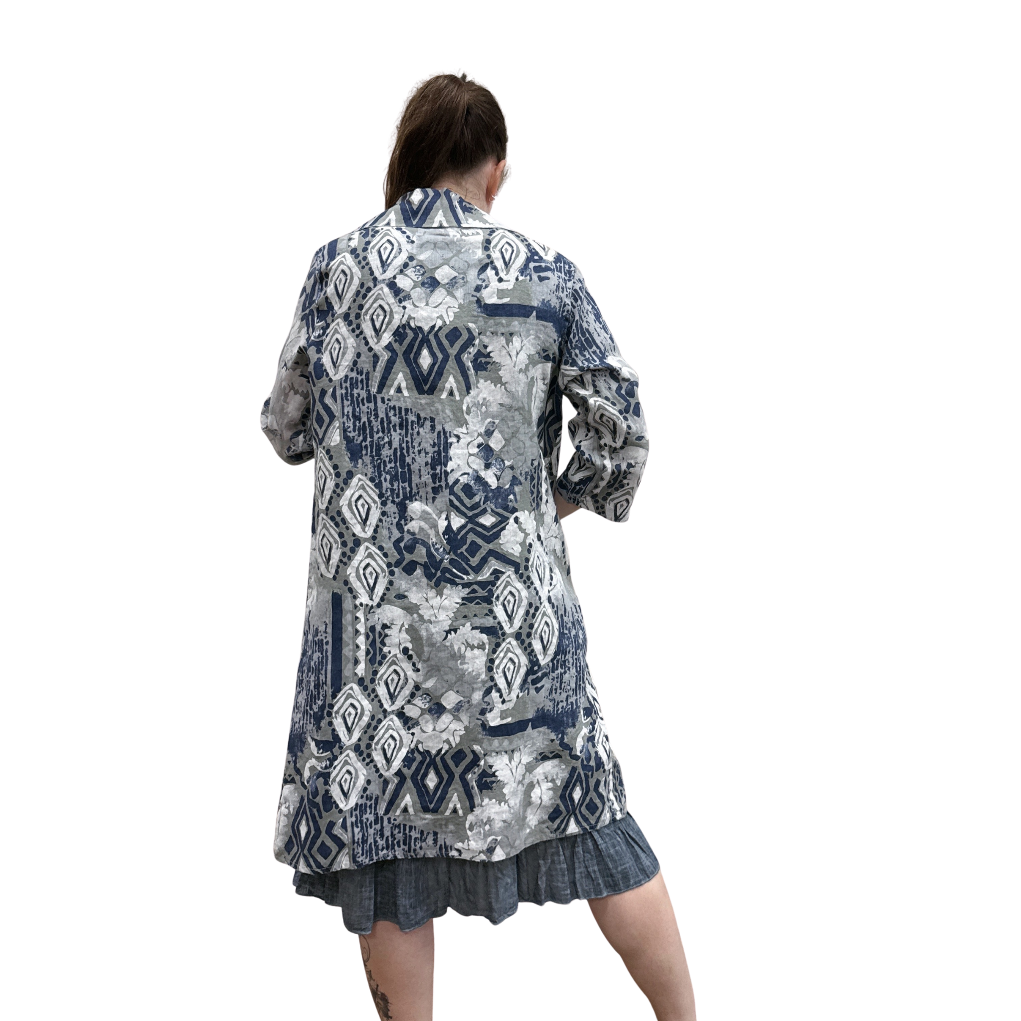 Person wearing a patterned shirt and skirt on a white background