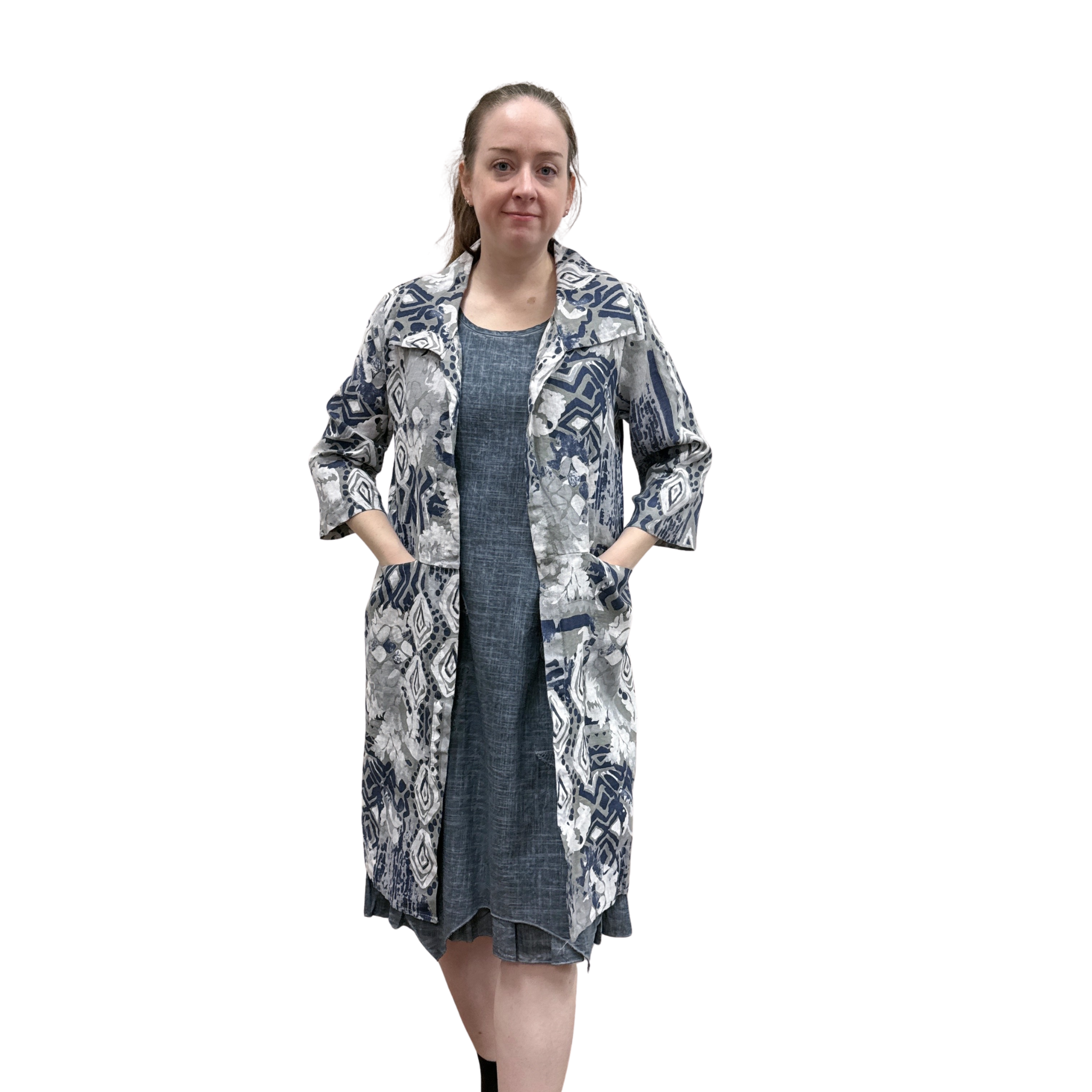 Woman wearing a patterned coat over a dress on a white background