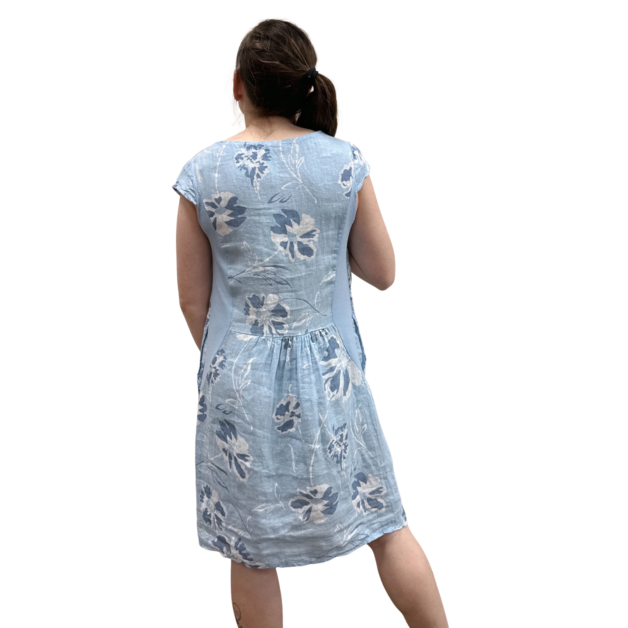 Woman wearing a light blue floral dress on a white background