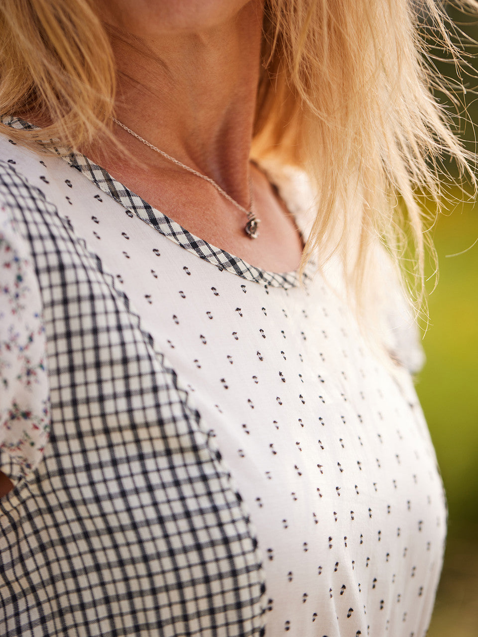 Close-up of a person wearing a checkered dress with a blurred background