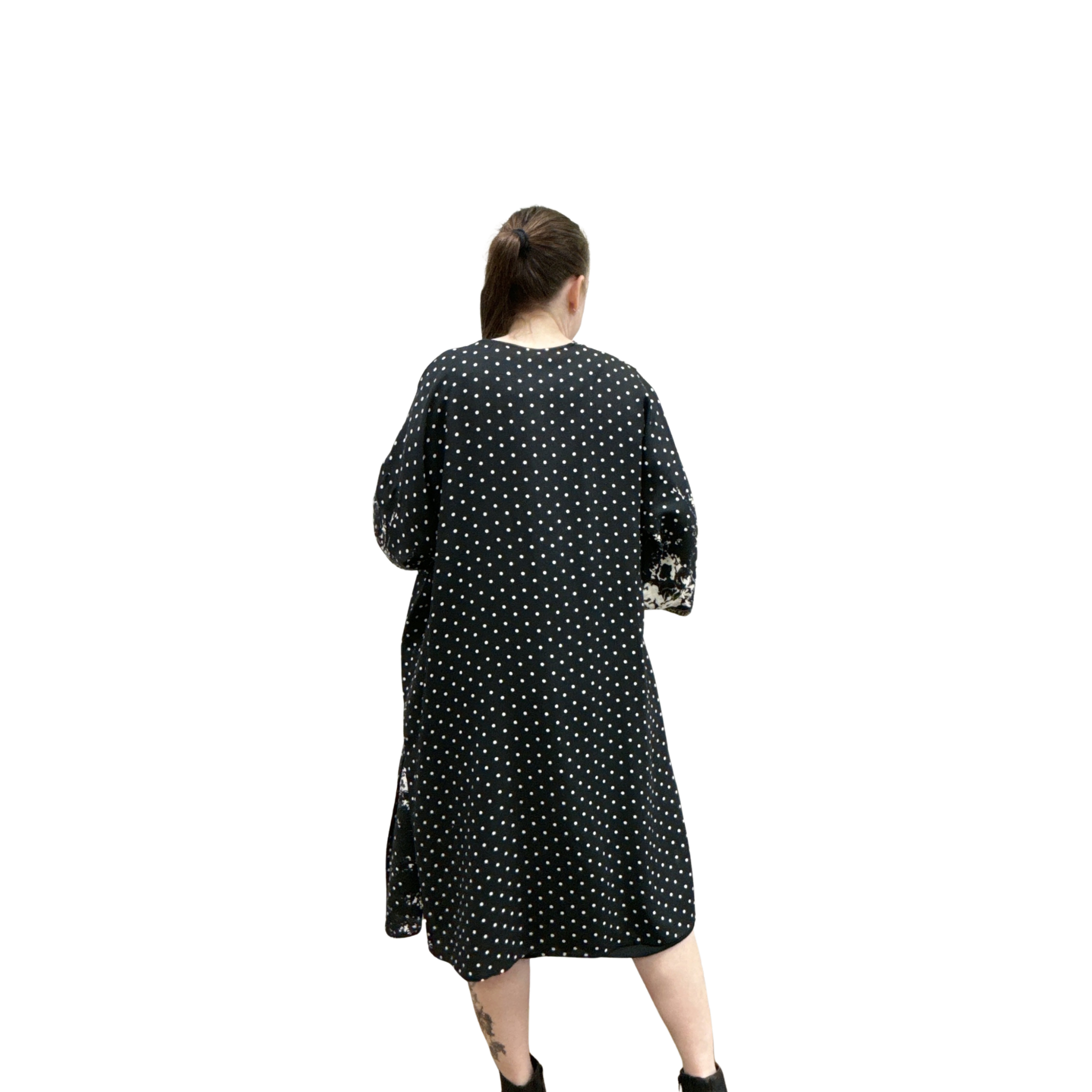 Woman wearing a black dress with white polka dots on a white background