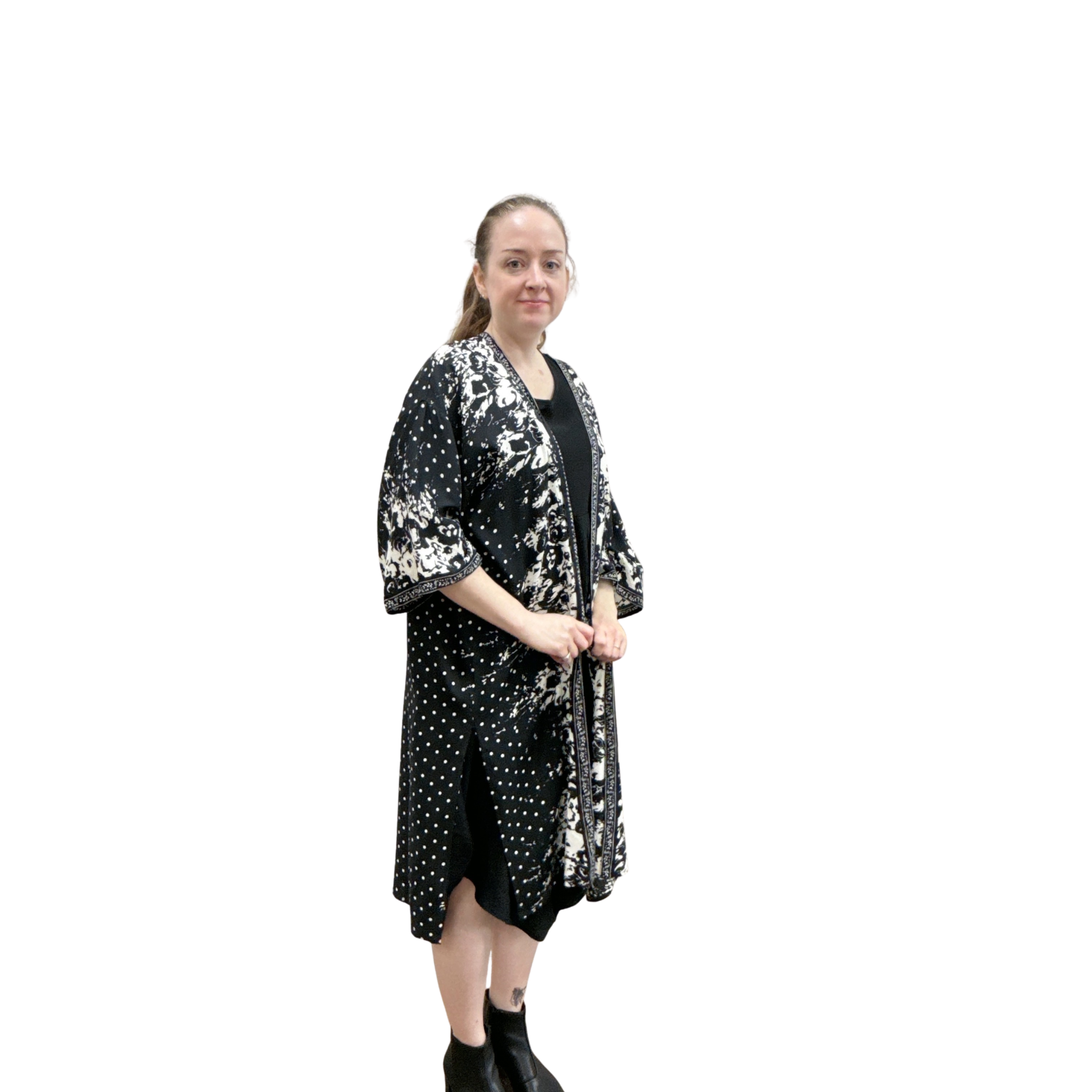 Woman wearing a black and white patterned kimono-style dress on a white background