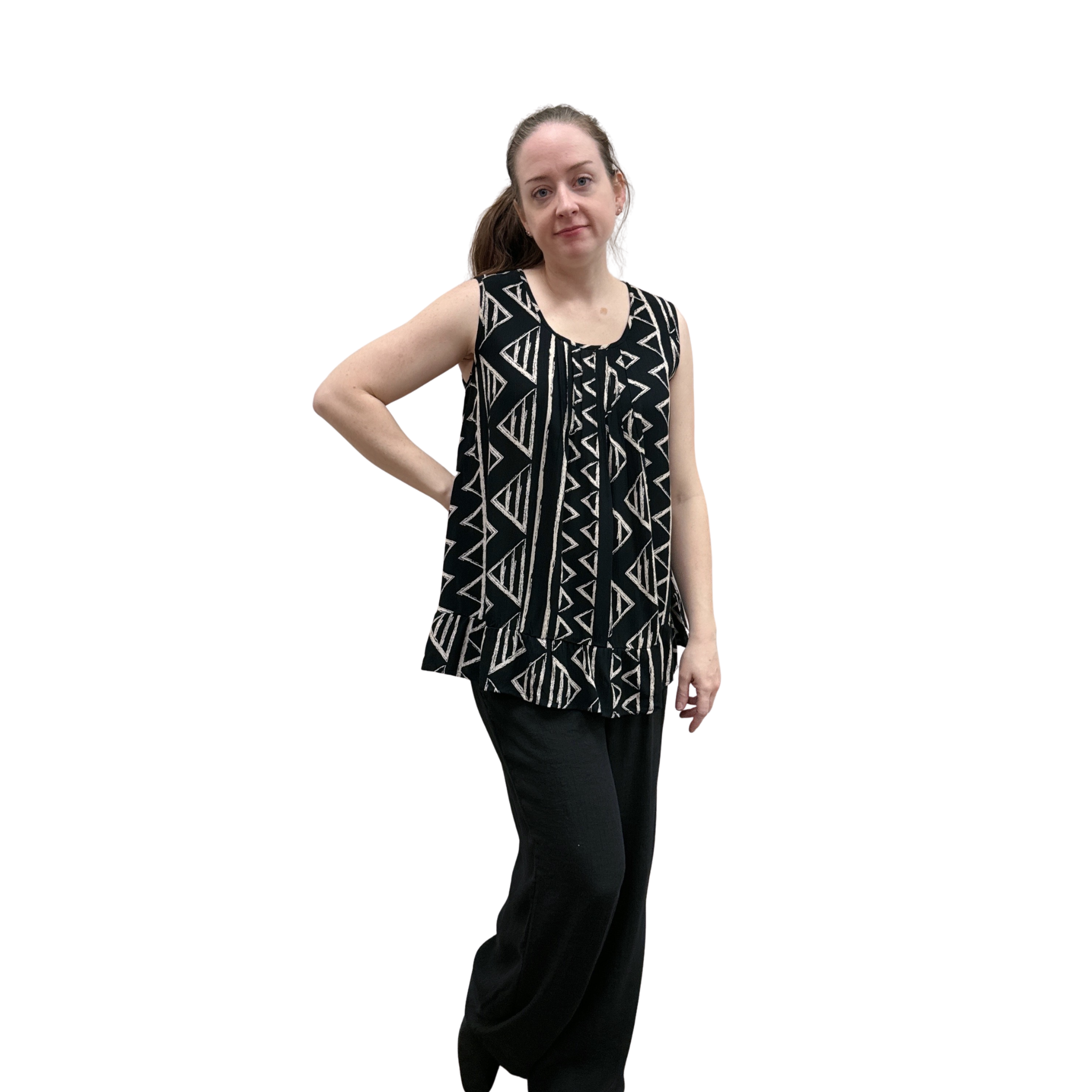 Woman wearing black with geometric print pattern sleeveless top with ruffle bottom on white background