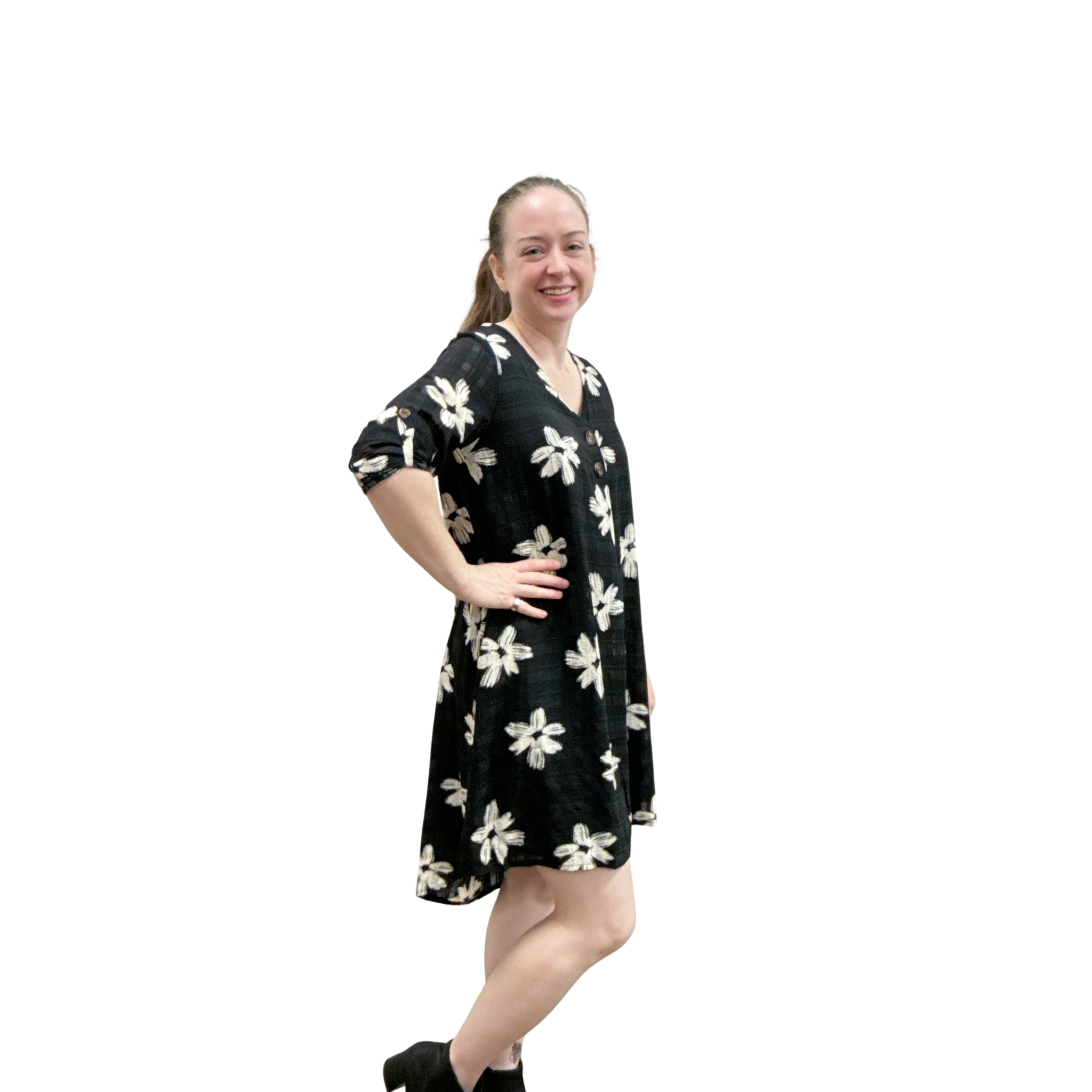 Woman wearing a black dress with white floral patterns on a white background