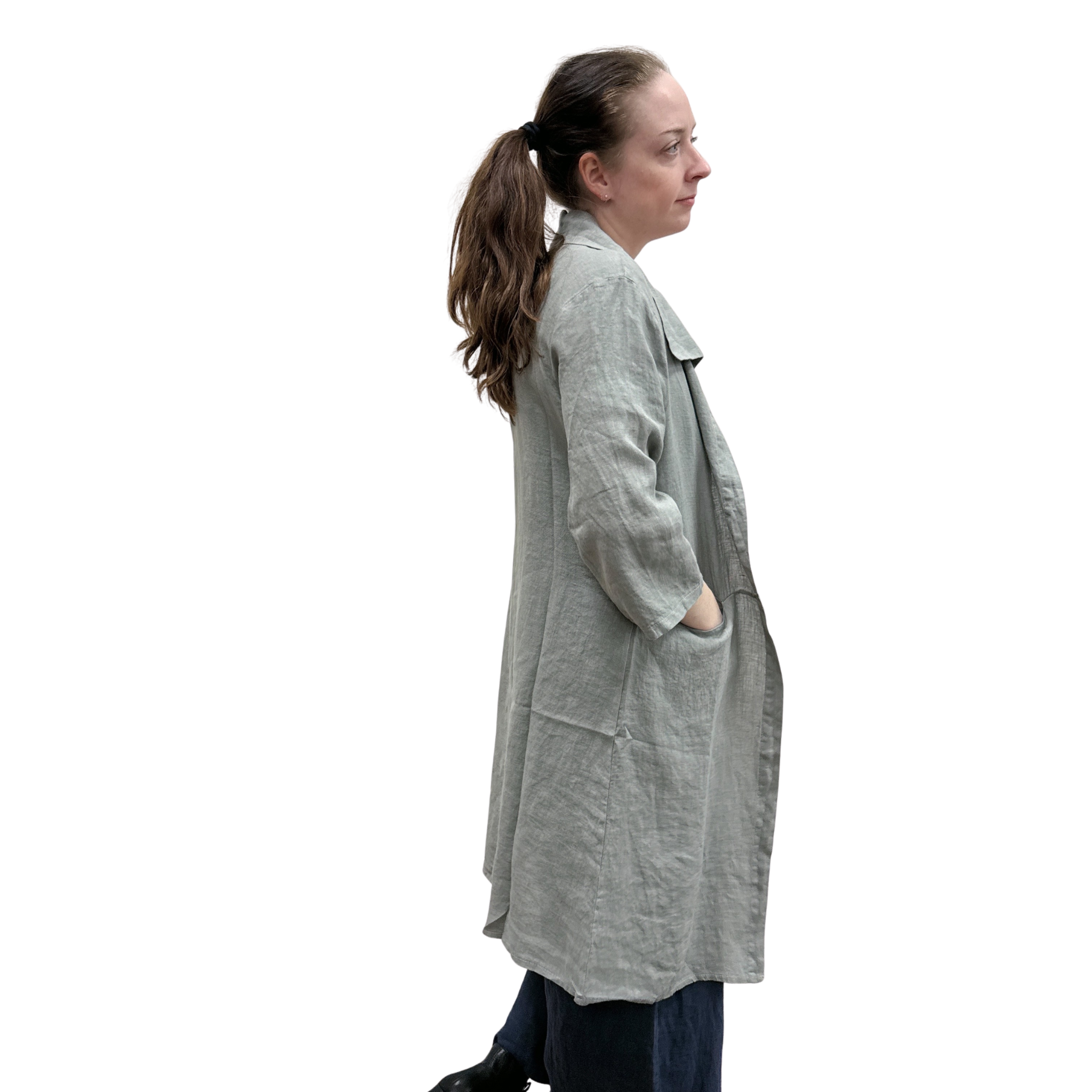 Woman wearing a long gray cardi over a dark jumpsuit on a white background