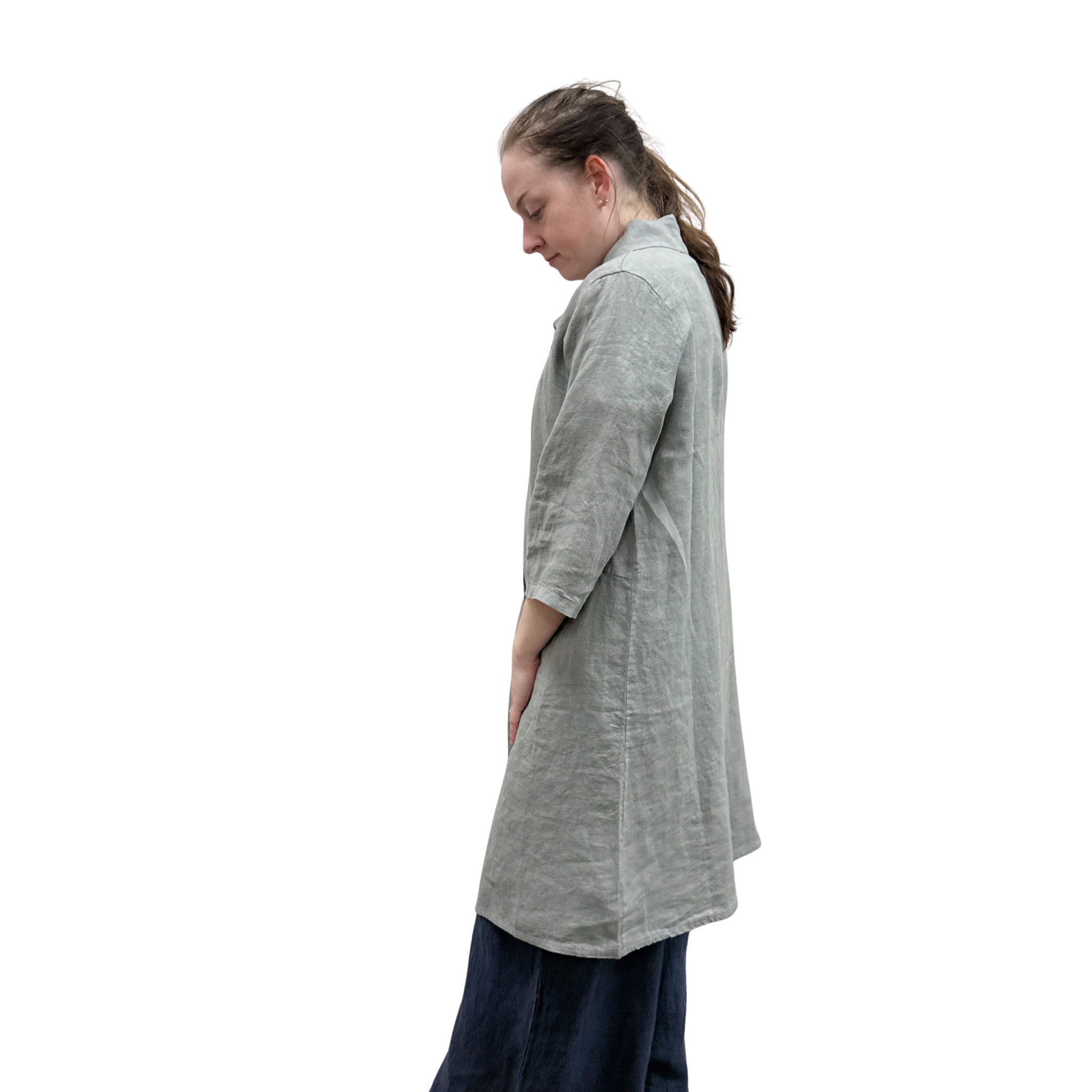 Woman wearing a long gray cardi over a dark jumpsuit on a white background