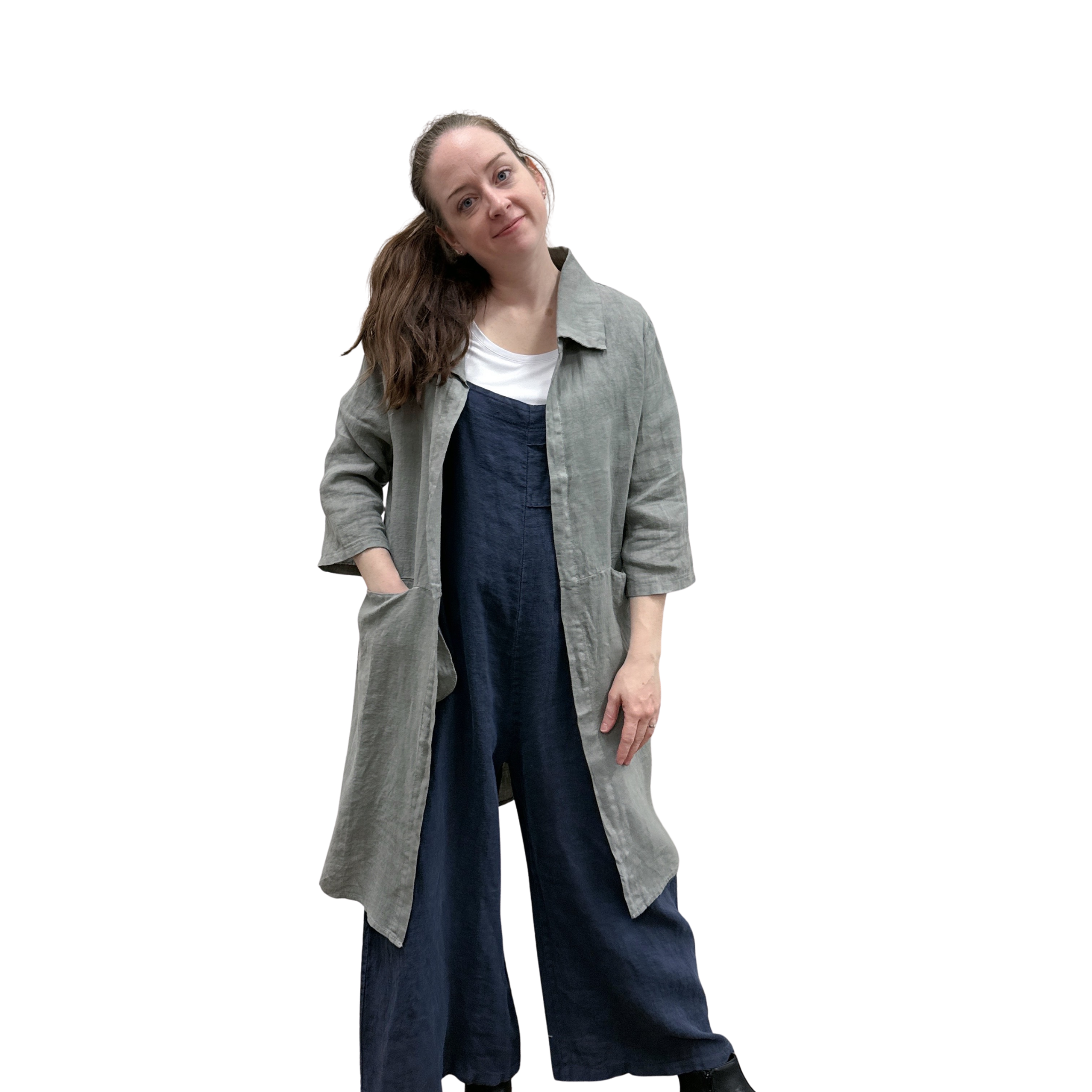 Woman wearing a long gray cardi over a dark jumpsuit on a white background