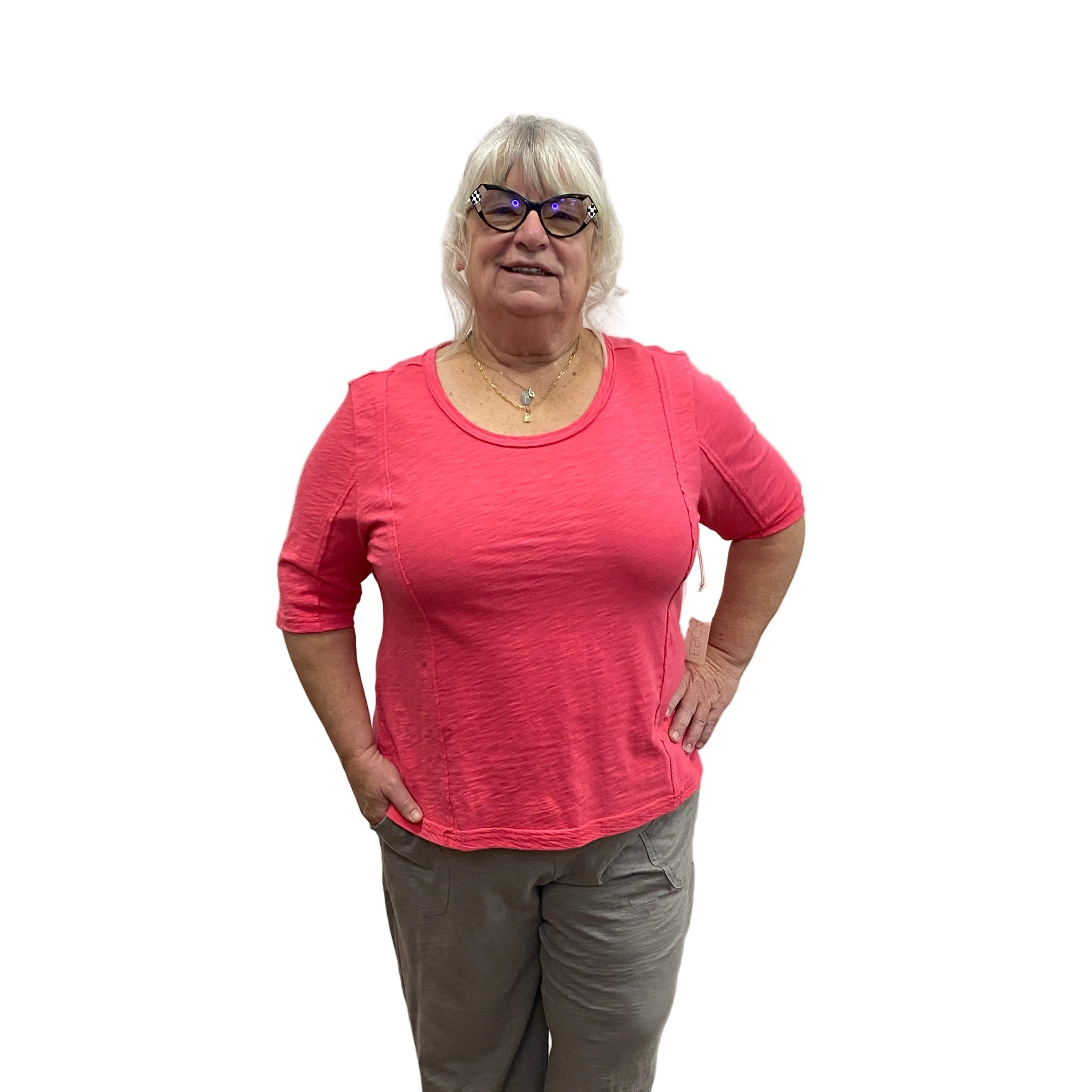 Person wearing a pink Papa Seamed Tee shirt and gray pants on white background.