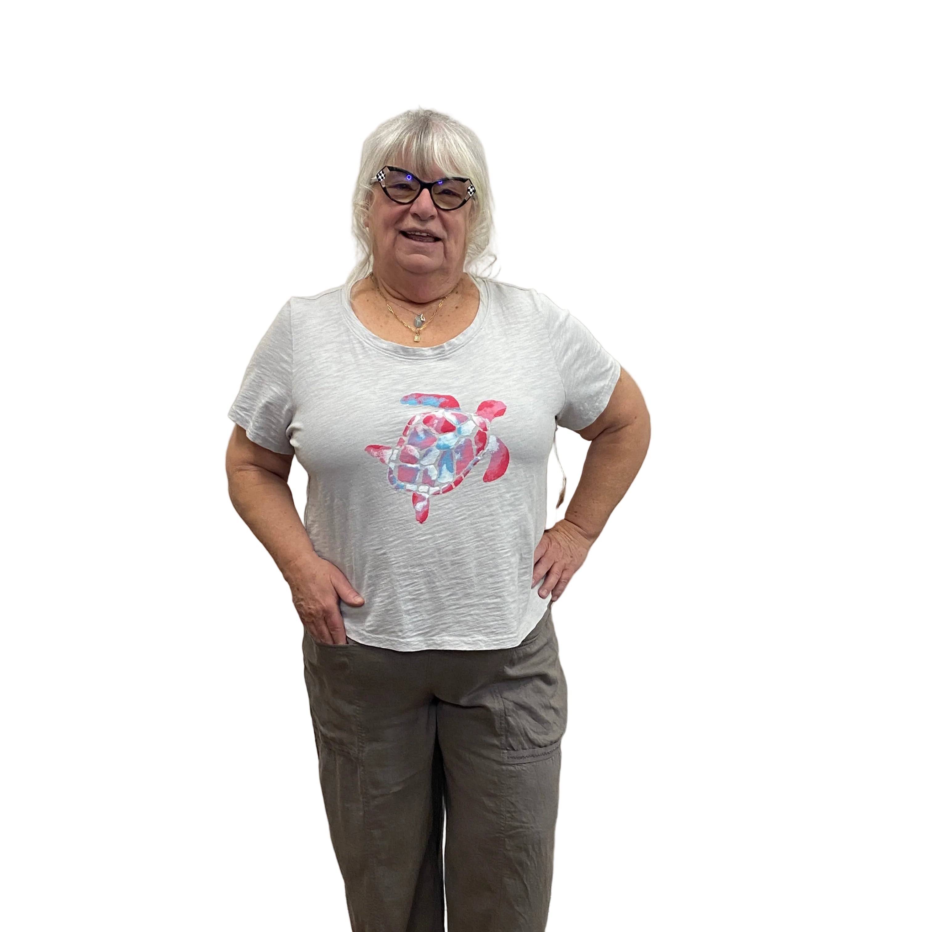 Person wearing a white Papa t-shirt with a pink turtle design and gray pants on white background.