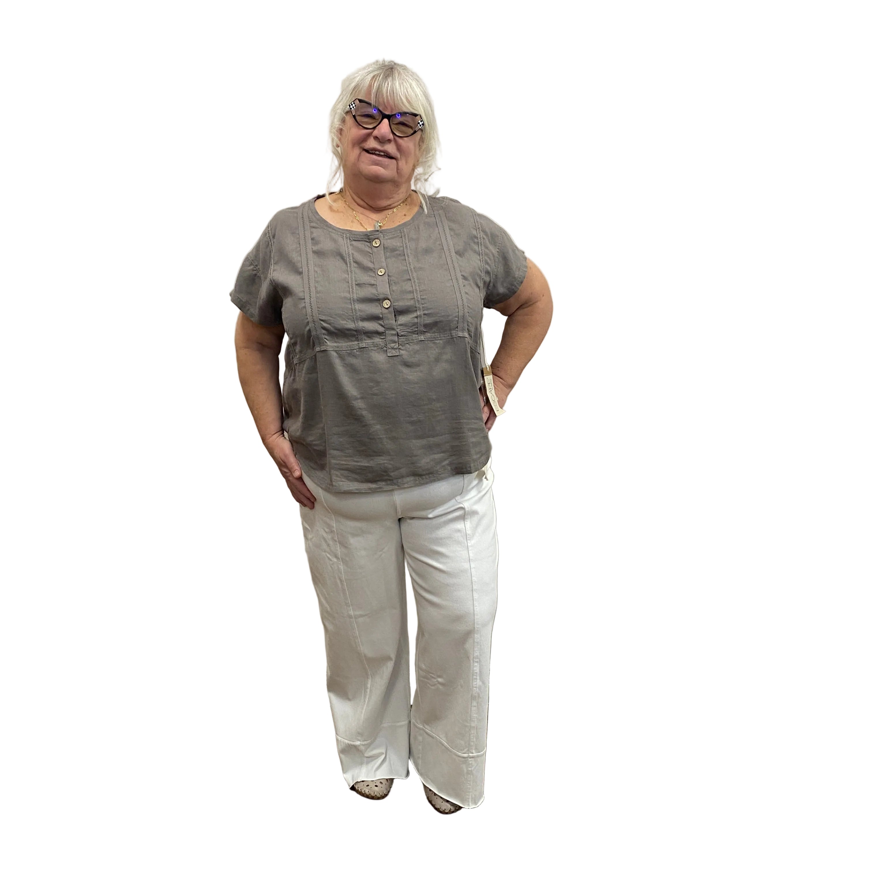 Person wearing a gray shirt and white pants on white background.