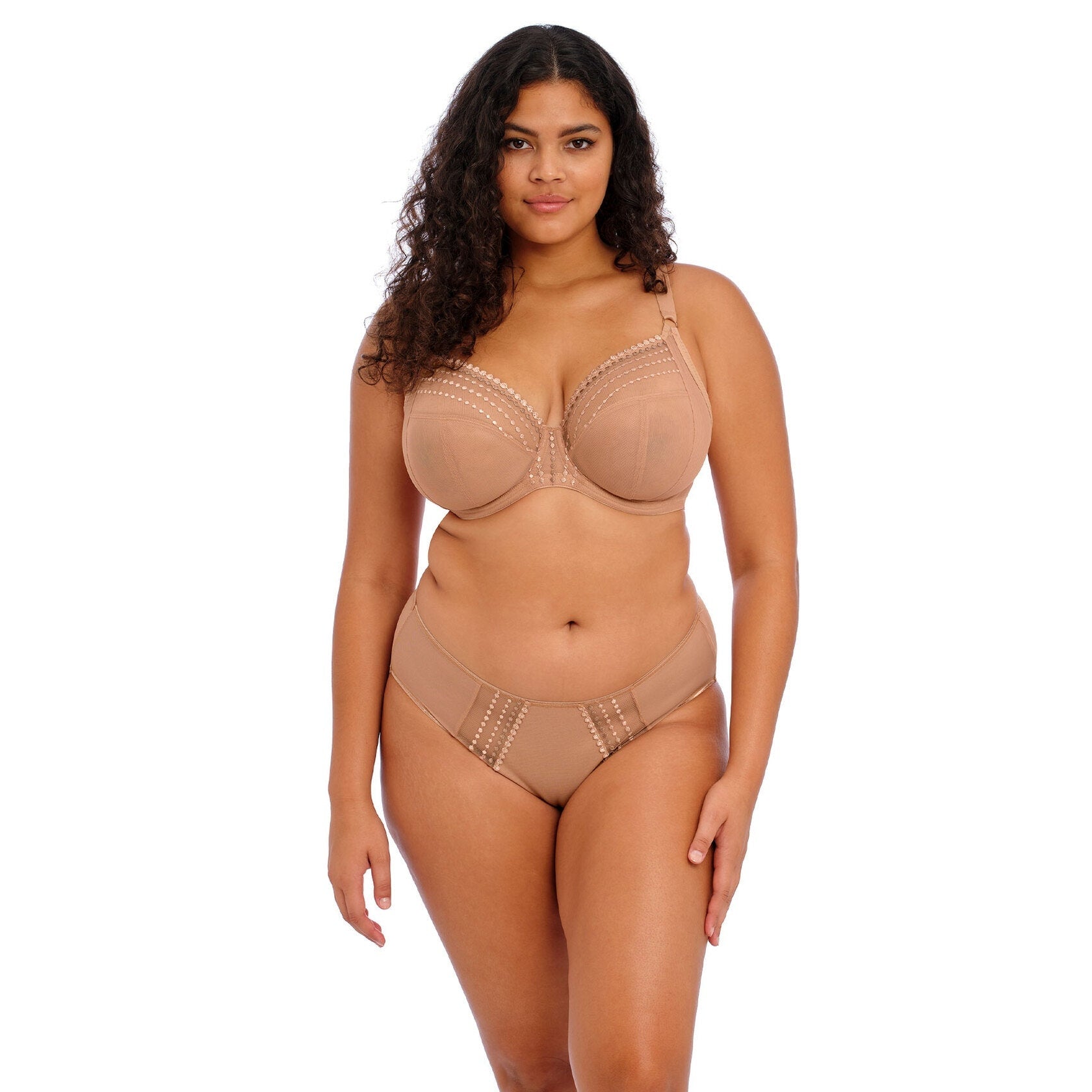 A woman wearing a beige bra and underwear set against a white background.