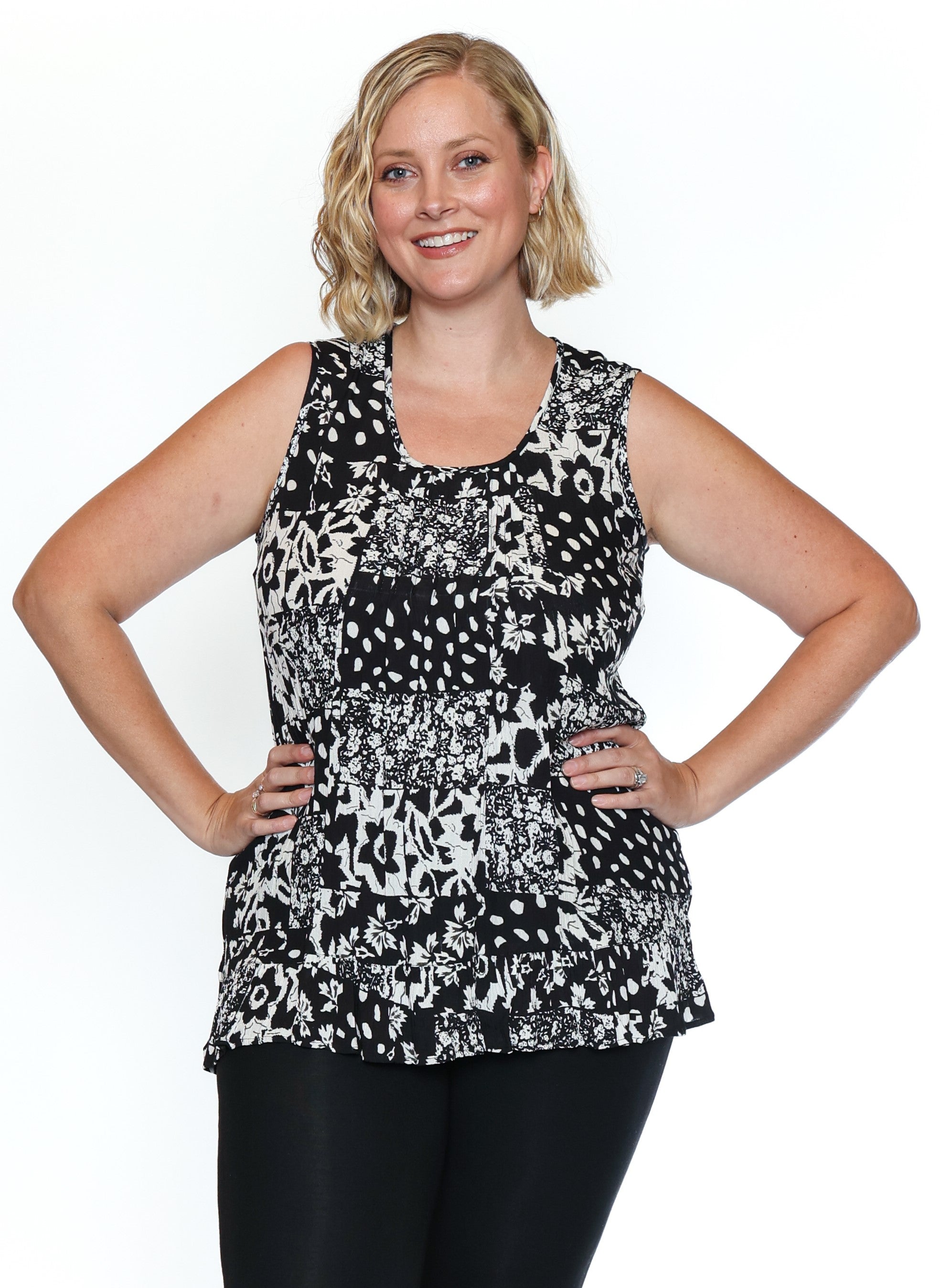 Woman wearing a black and white patterned sleeveless top on a white background