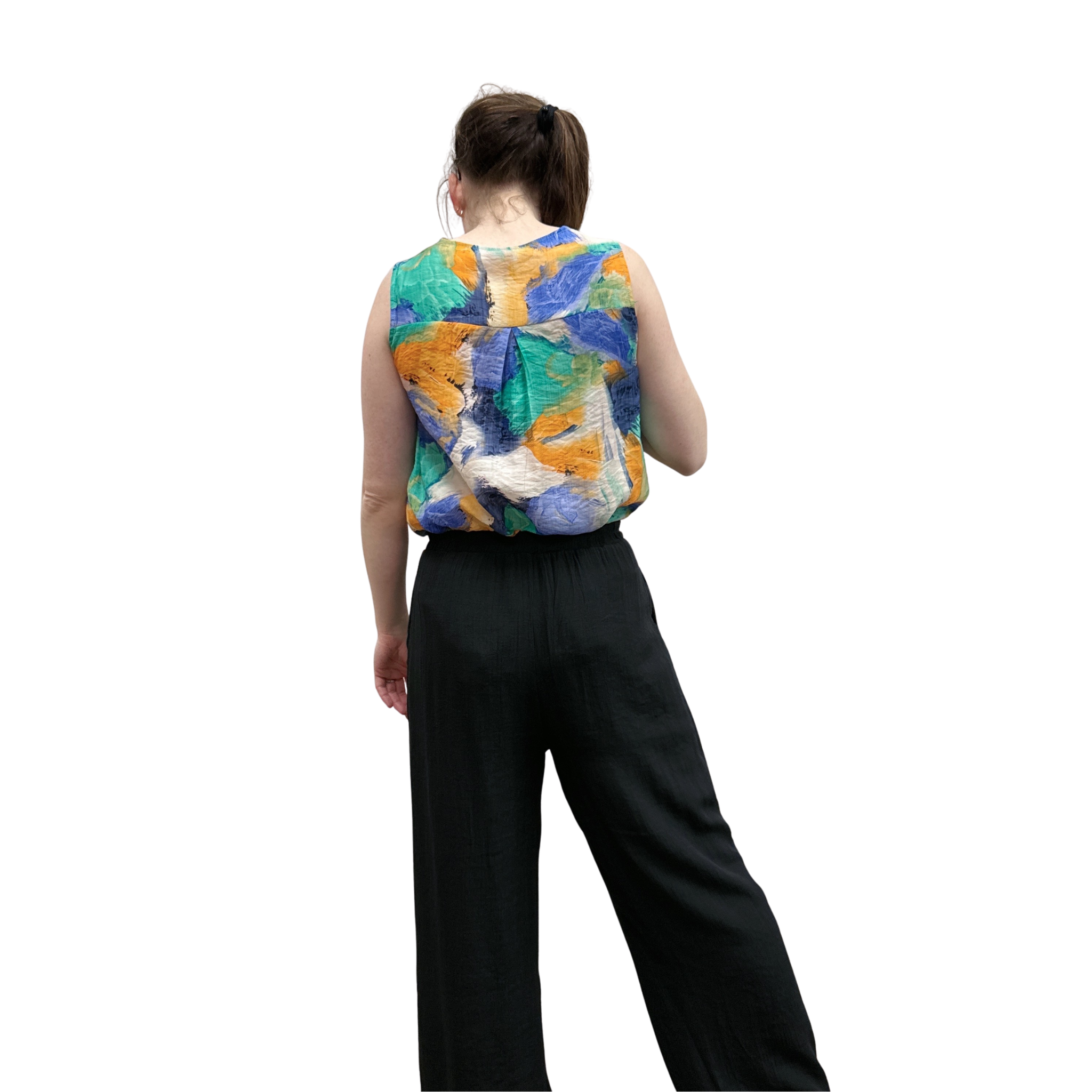 Person wearing a colorful sleeveless top with abstract patterns on a white background