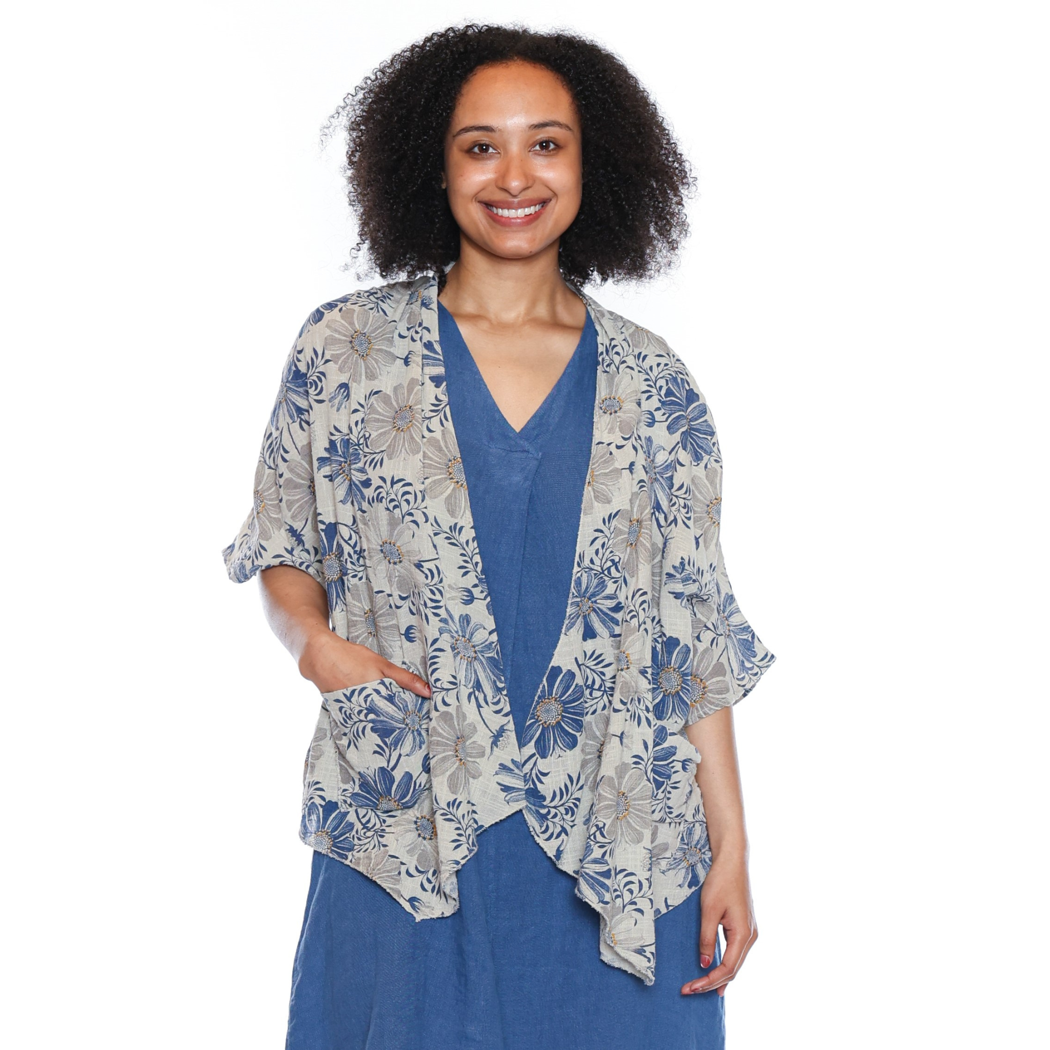 Woman wearing a floral kimono over a blue dress on a white background