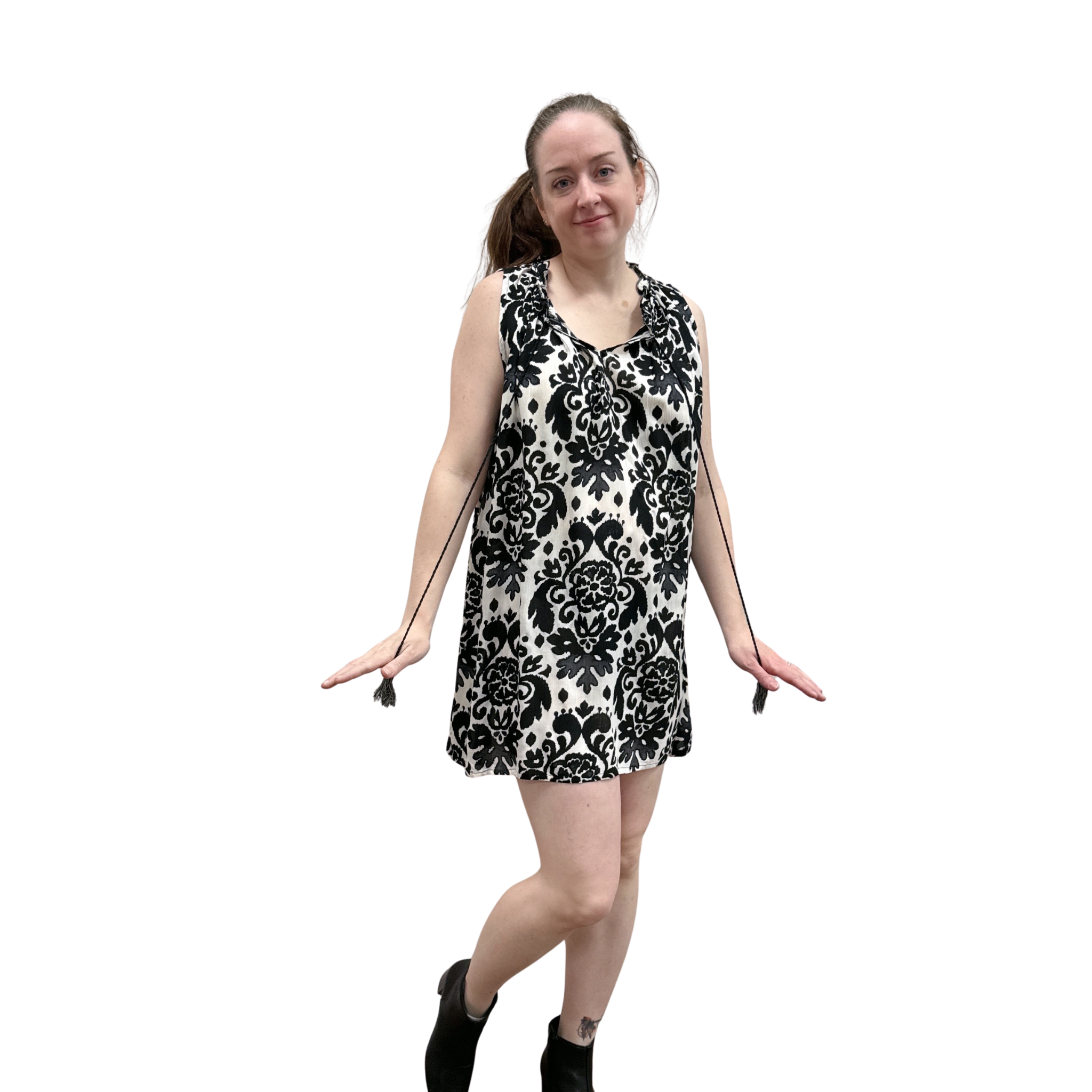 Woman wearing a black and white patterned sleeveless dress on a white background