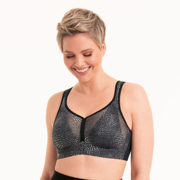Woman wearing a black patterned sports bra on a white background