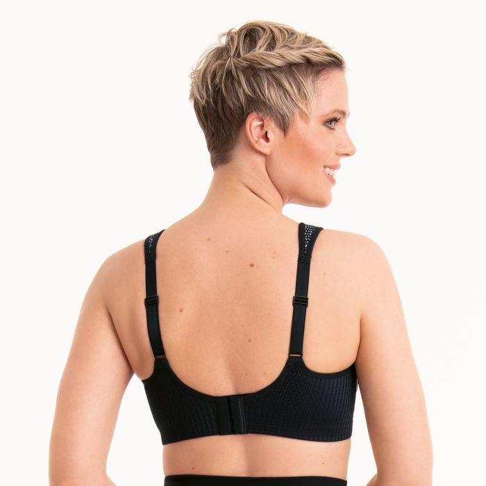 Woman wearing a black sports bra on a white background