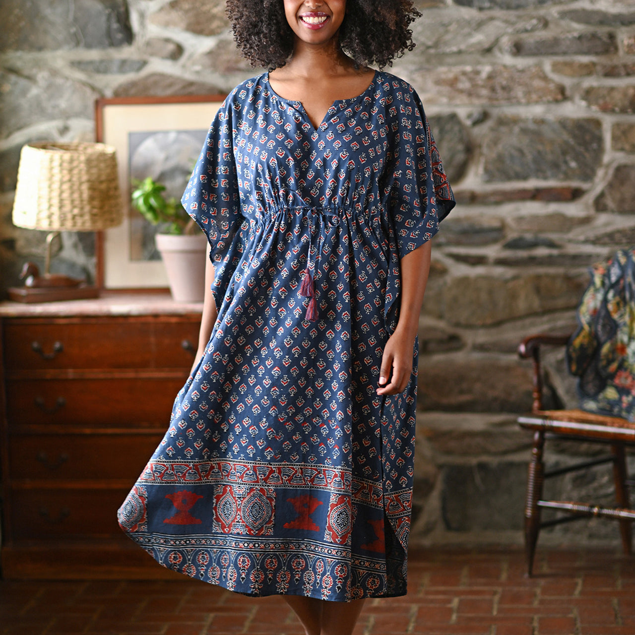 Woman wearing a blue check dress in a living room