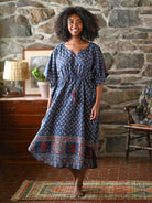 Woman wearing a blue check dress in a living room