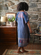 A person wearing a blue check dress in a living room