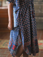 A person wearing a blue and red dress with a side slit