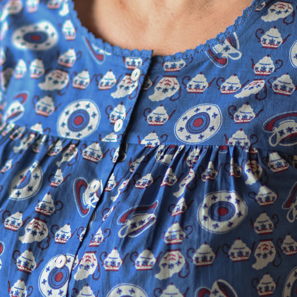 A person wearing a blue and white shirt with buttons.