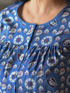 A person wearing a blue and white shirt with buttons.