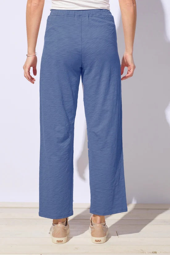 Blue pants worn by a person on a white background