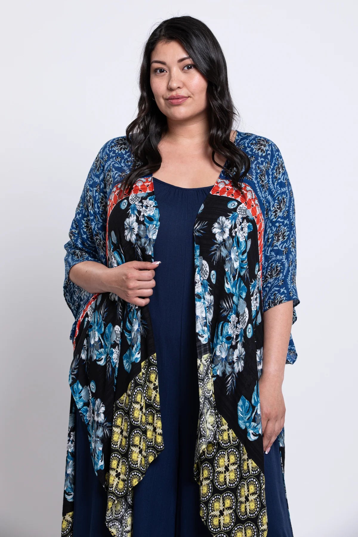 Woman wearing a floral kimono-style jacket over a dark dress on a white background