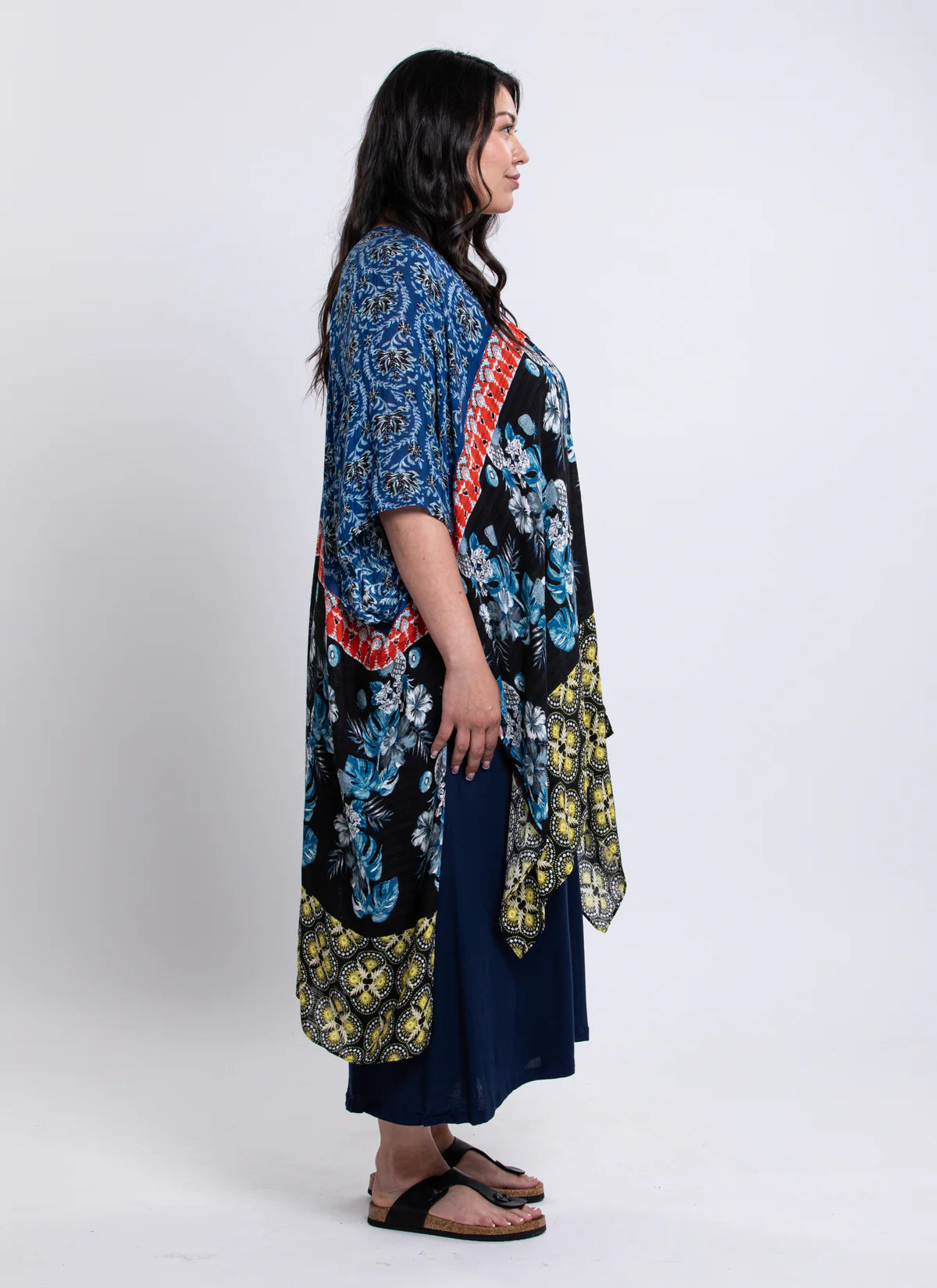 Woman wearing a long, patterned dress with a blue floral design on a white background