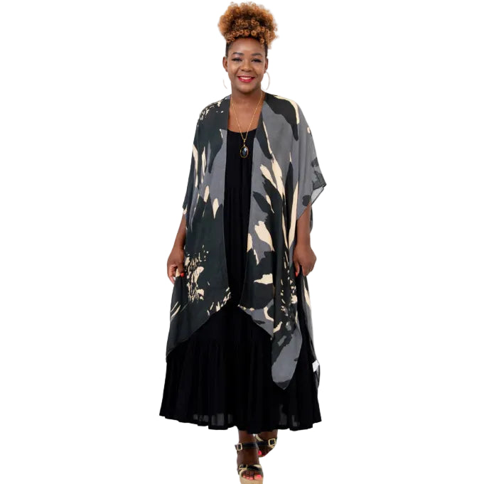 Woman wearing a long, patterned kimono over a black dress on a white background