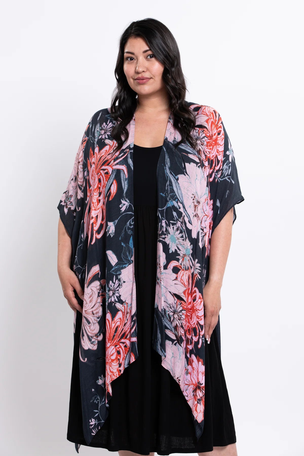 Woman wearing a floral kimono over a black dress on a white background
