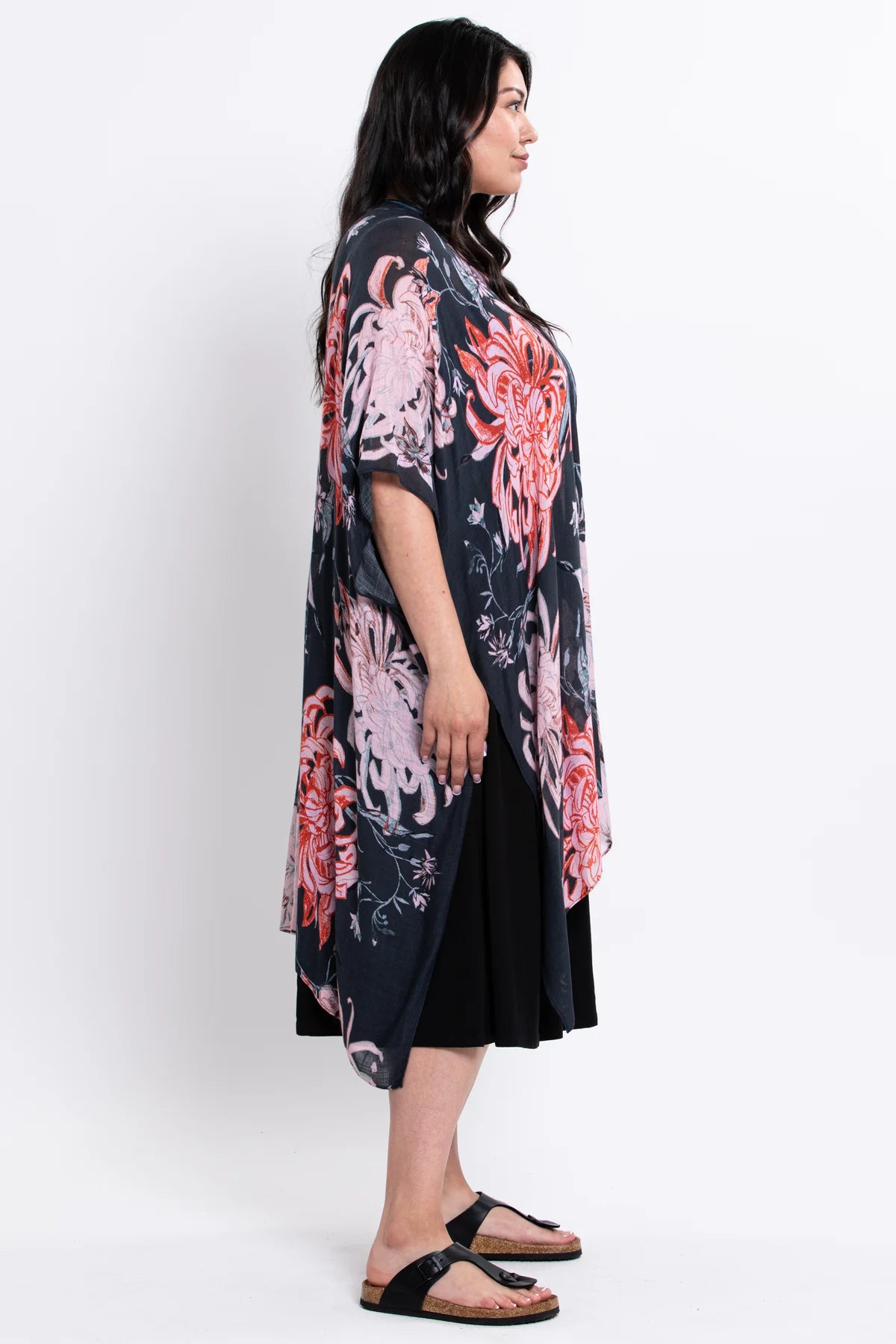 Woman wearing a floral kimono-style garment on a white background