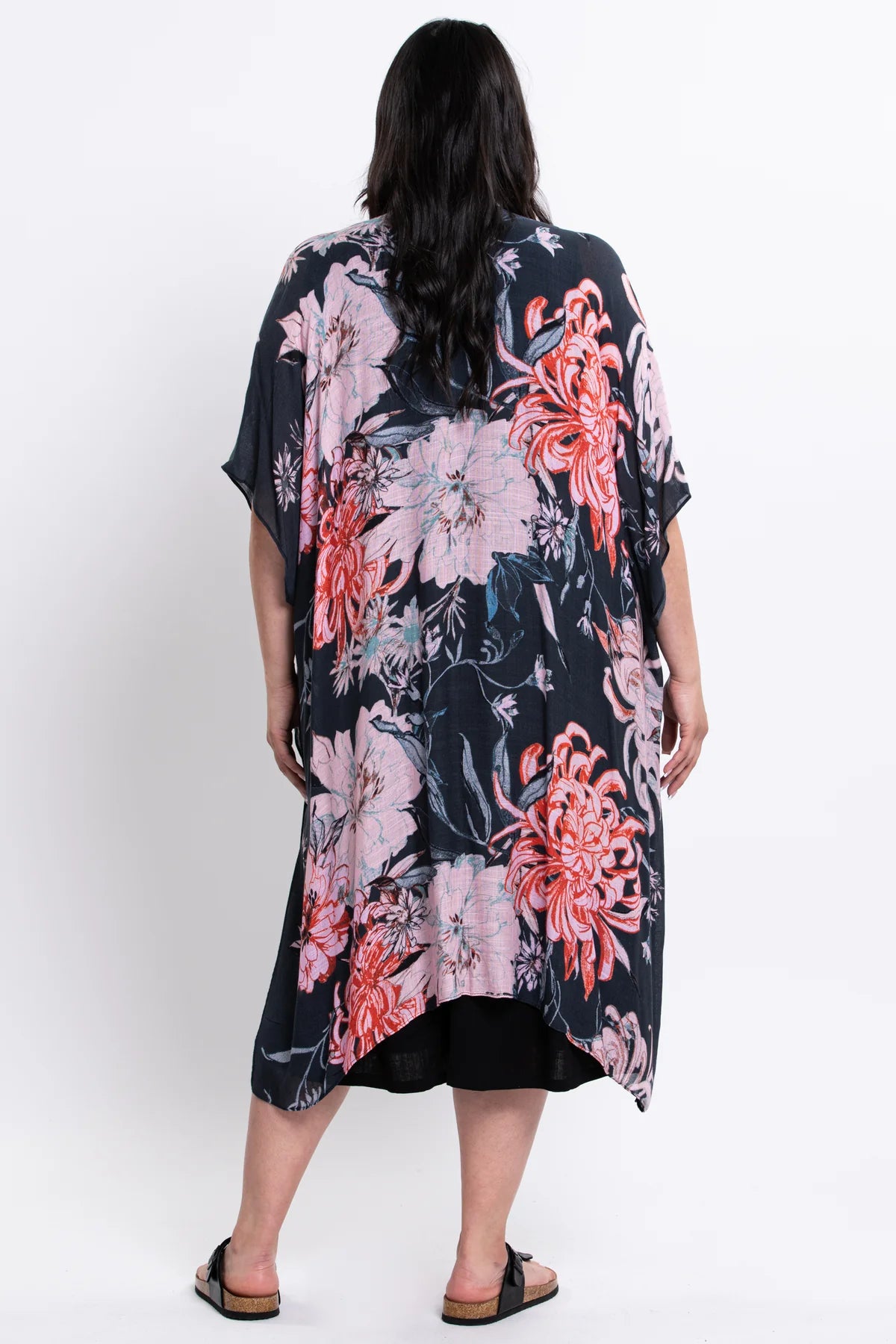 Woman wearing a floral kimono-style garment on a white background