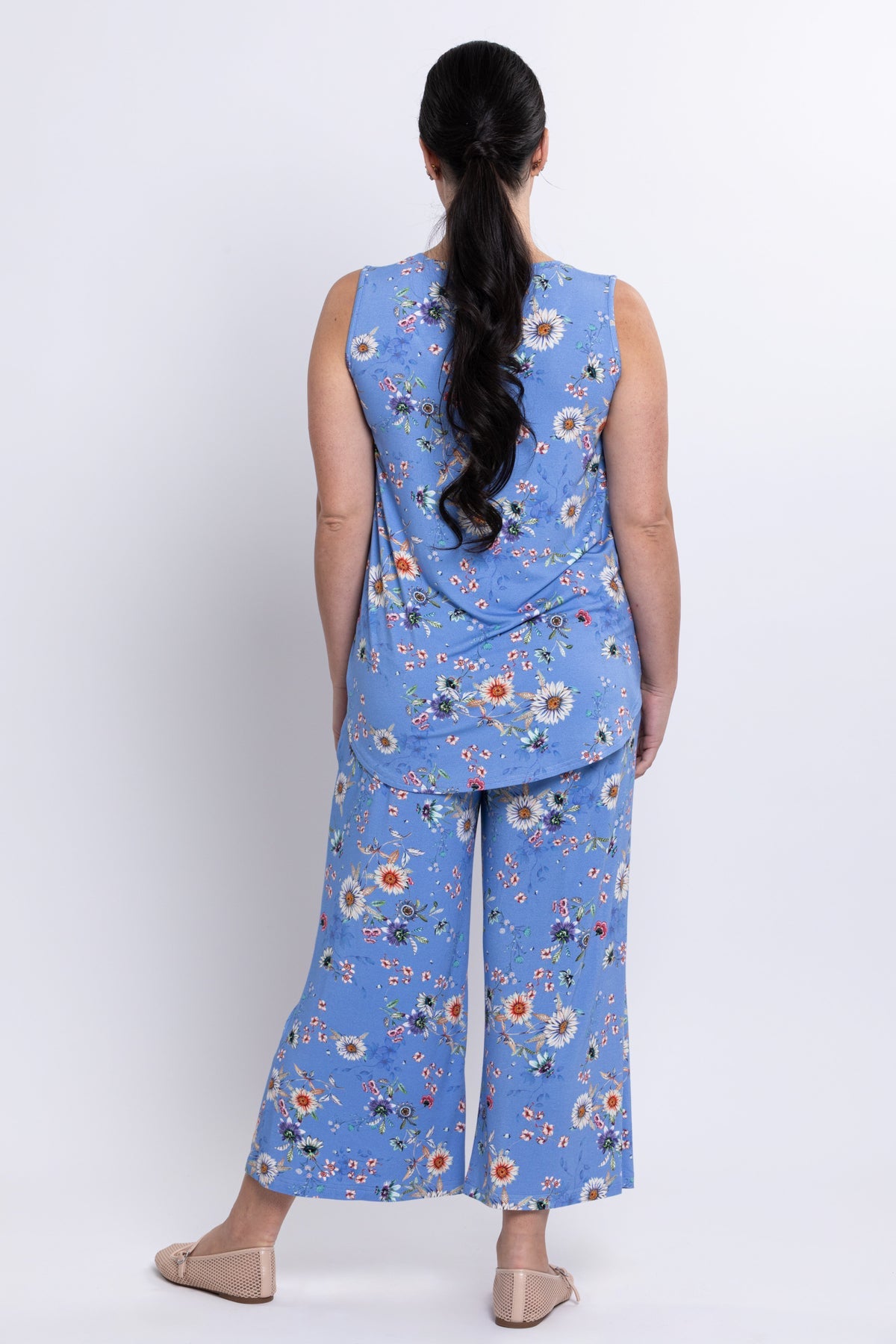 Woman wearing a blue floral outfit with a white background