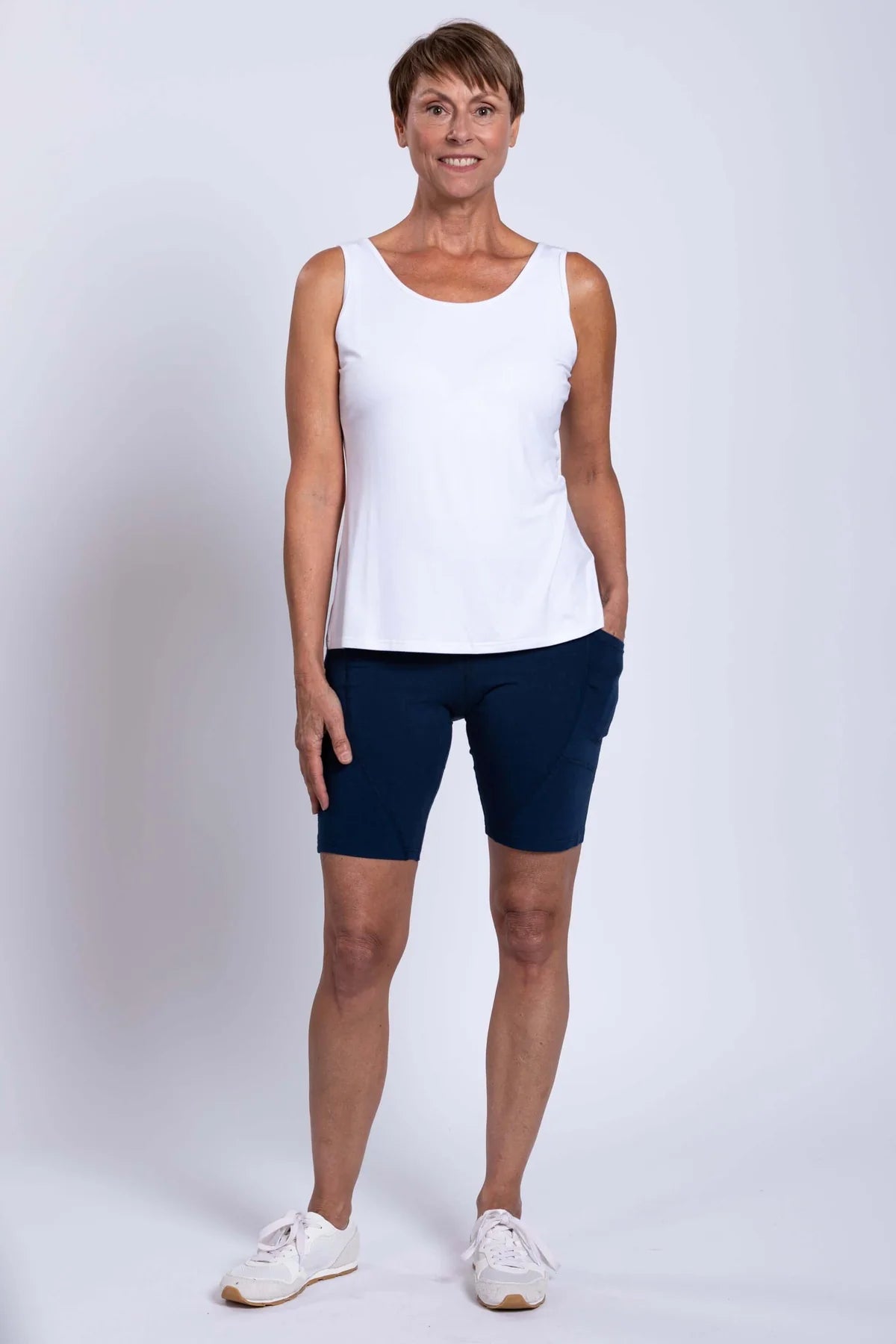 Woman wearing blue sky robson bamboo shorts in the colour indigo on a white background.