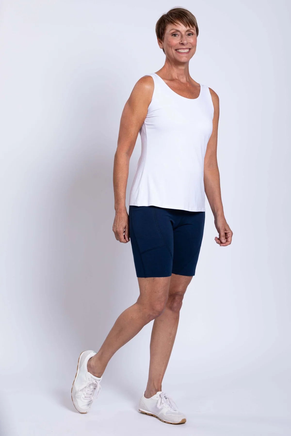 Woman wearing blue sky robson bamboo shorts in the colour indigo on a white background.