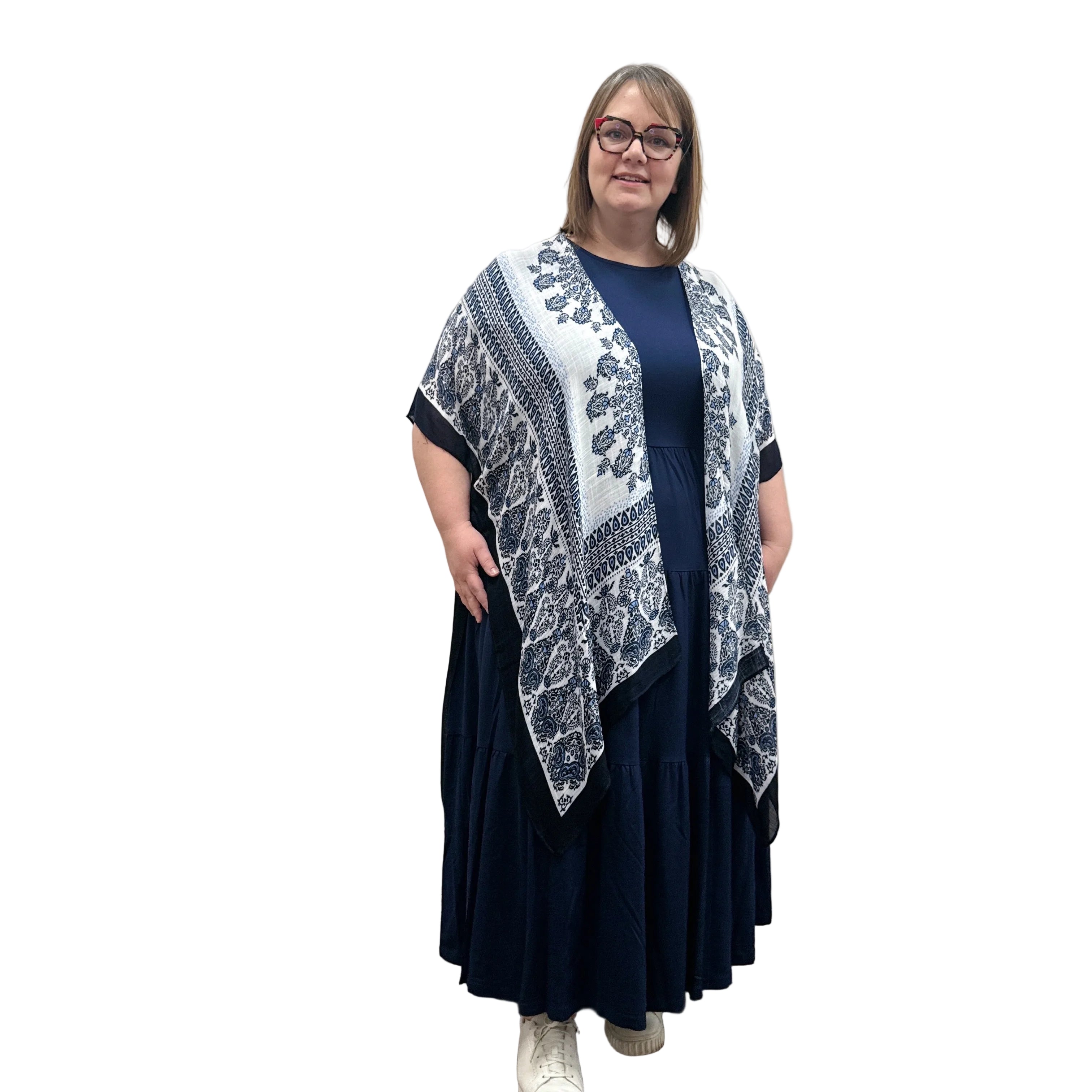 Woman wearing a blue and white patterned Blue Sky Darcy kimono over a dark dress on a white background