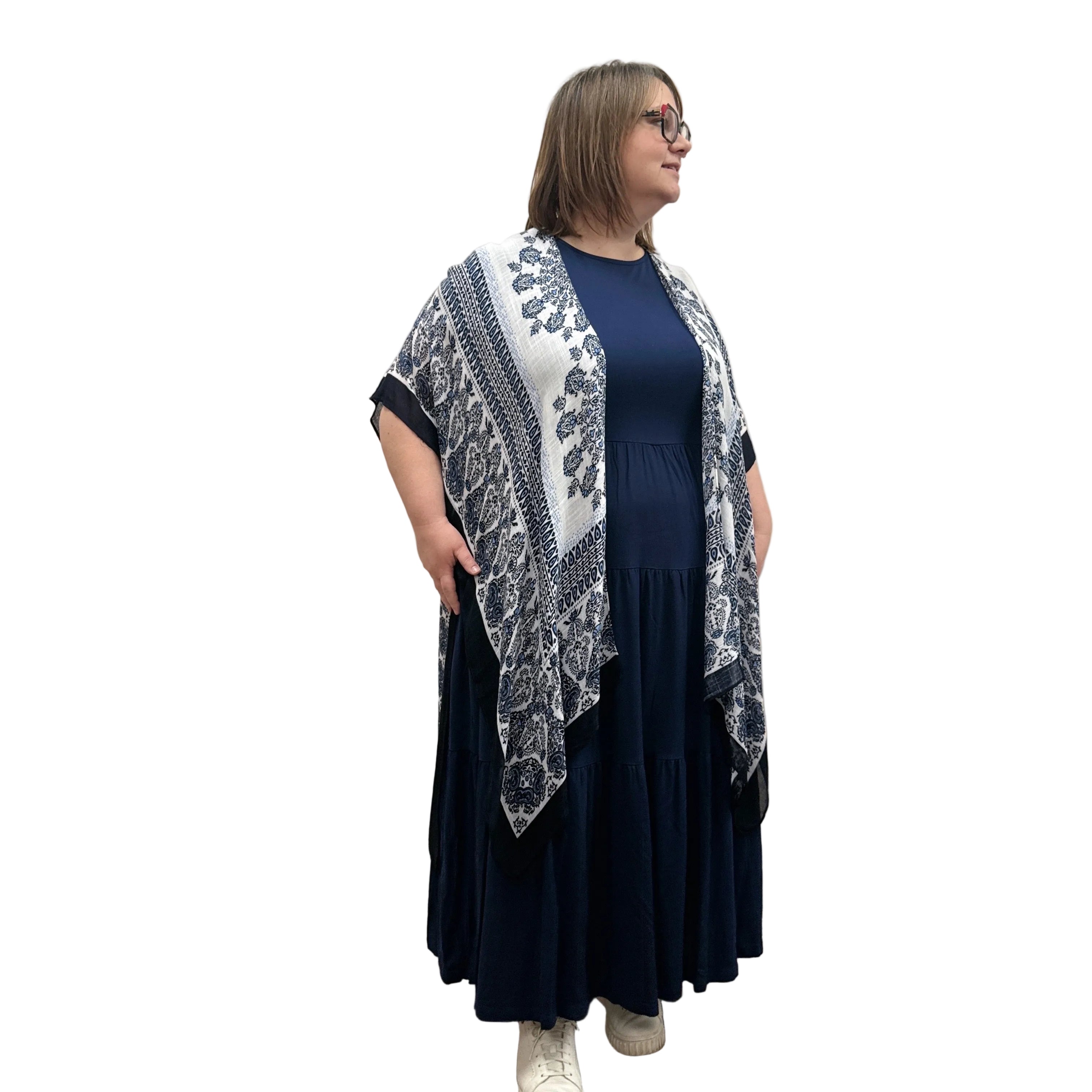 Woman wearing a blue and white patterned Blue Sky Darcy kimono over a dark dress on a white background
