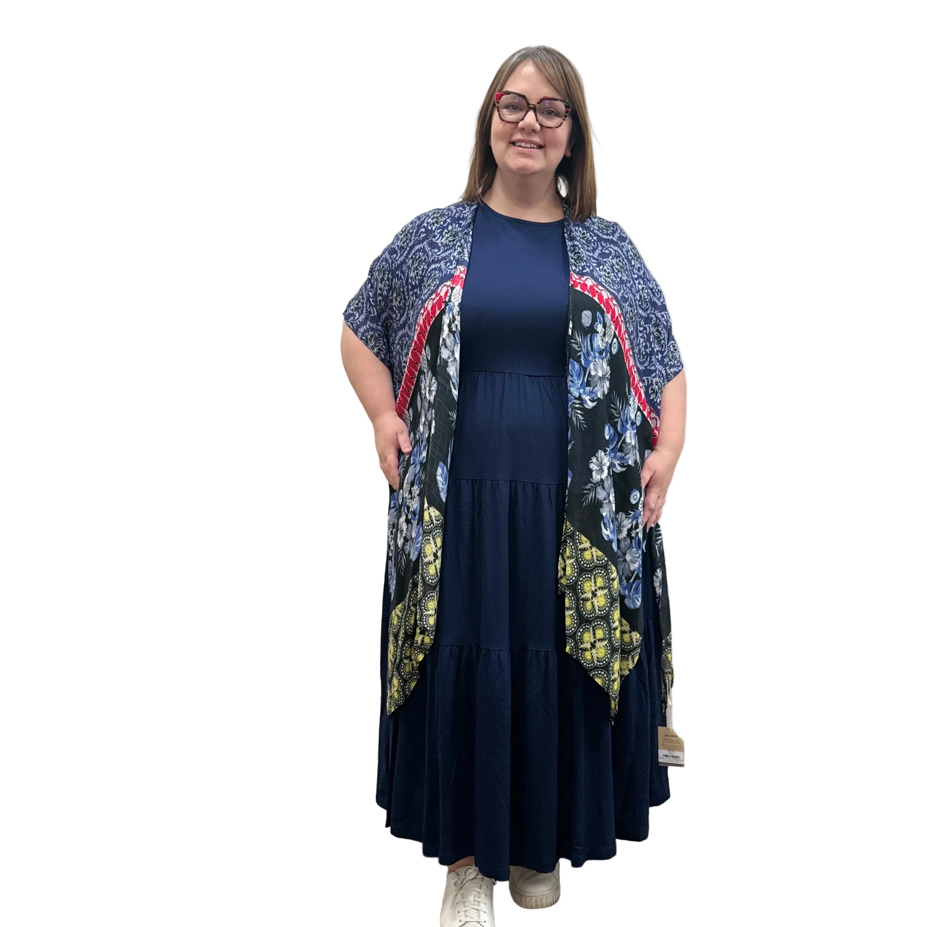 Woman wearing a navy dress with a floral Blue Sky Darcy kimono on a white background.