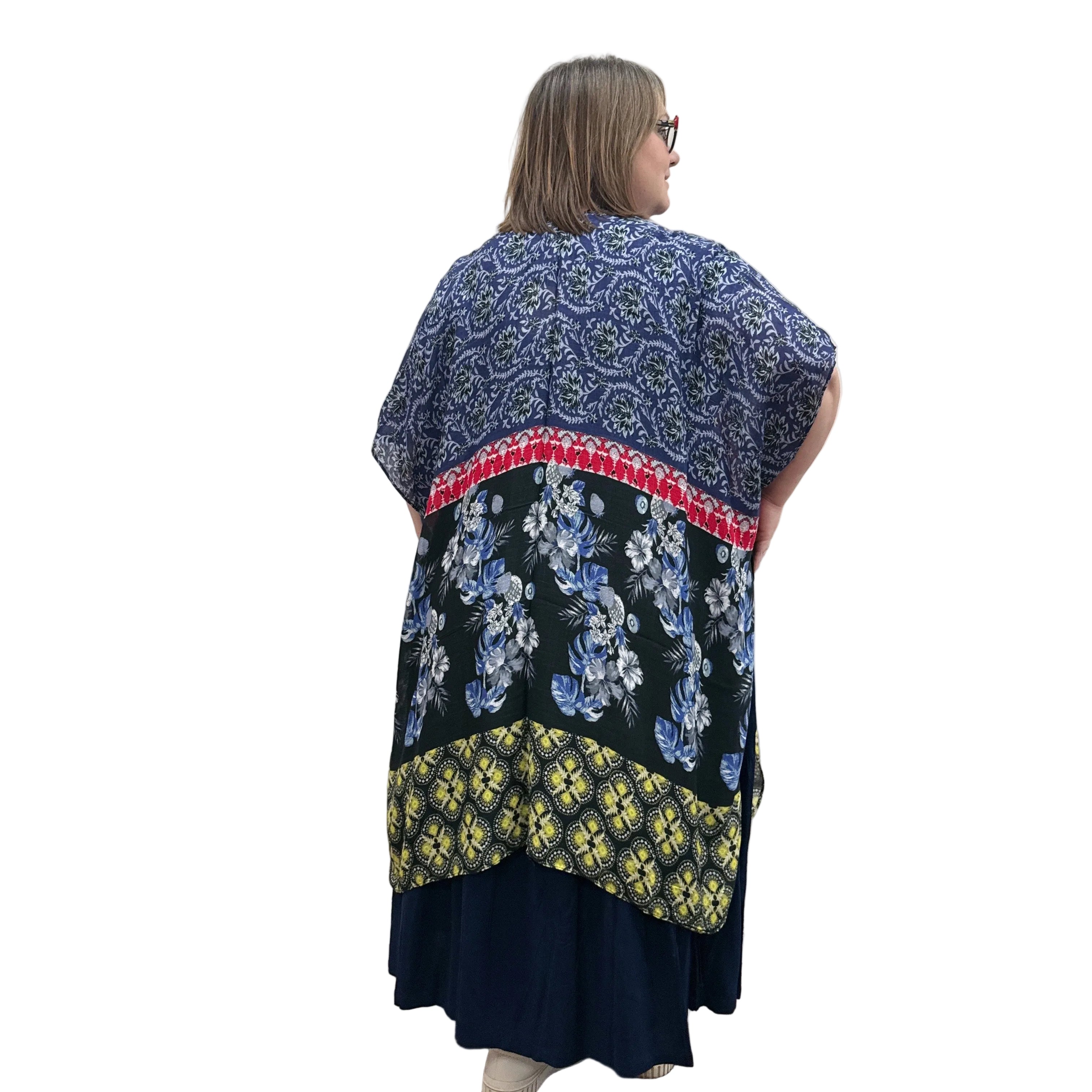 Woman wearing a navy dress with a floral Blue Sky Darcy kimono on a white background.