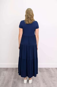 Woman wearing a dark blue Blue Sky Erin dress against a white background