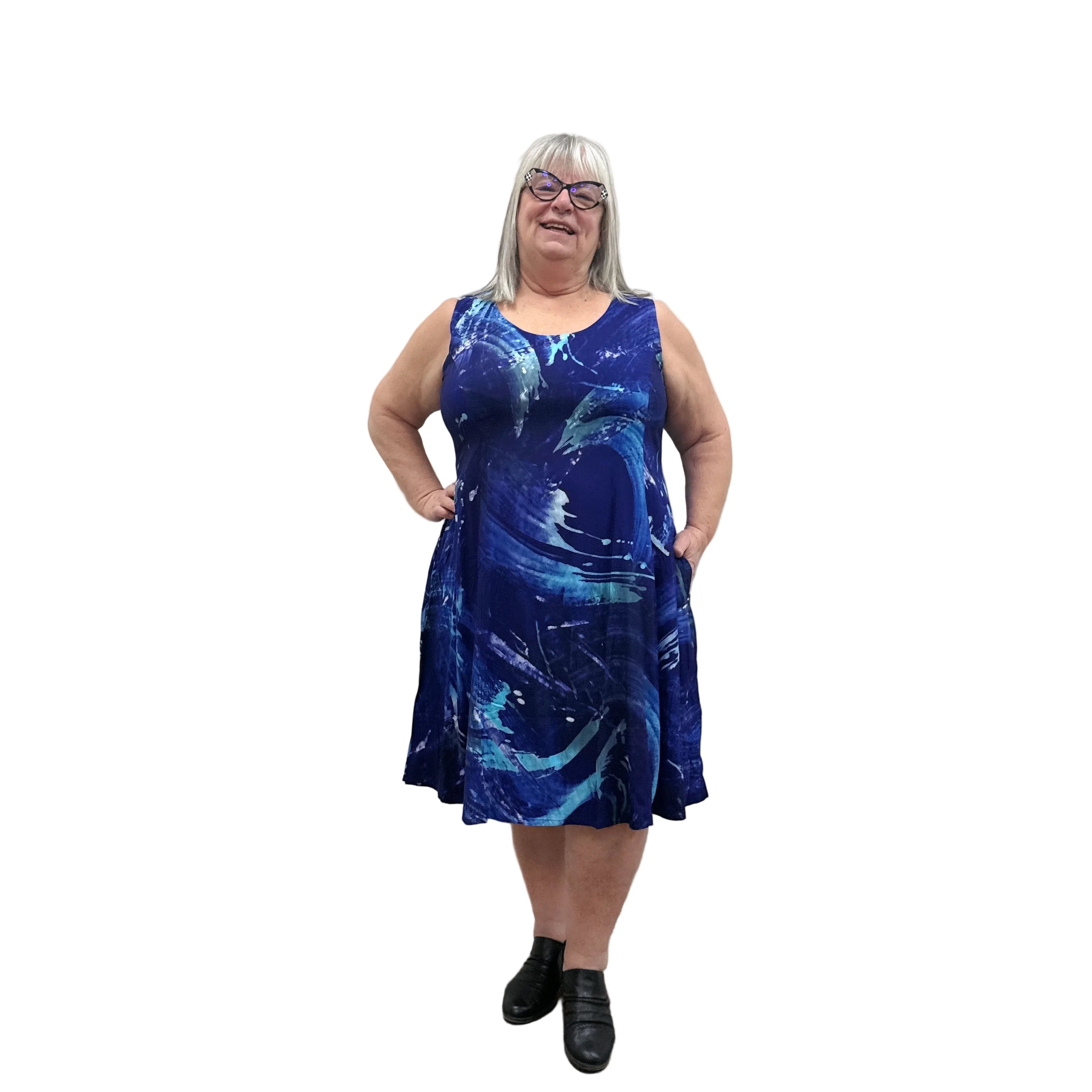 Woman wearing a blue patterned Blue Sky Sara Dress on white background.