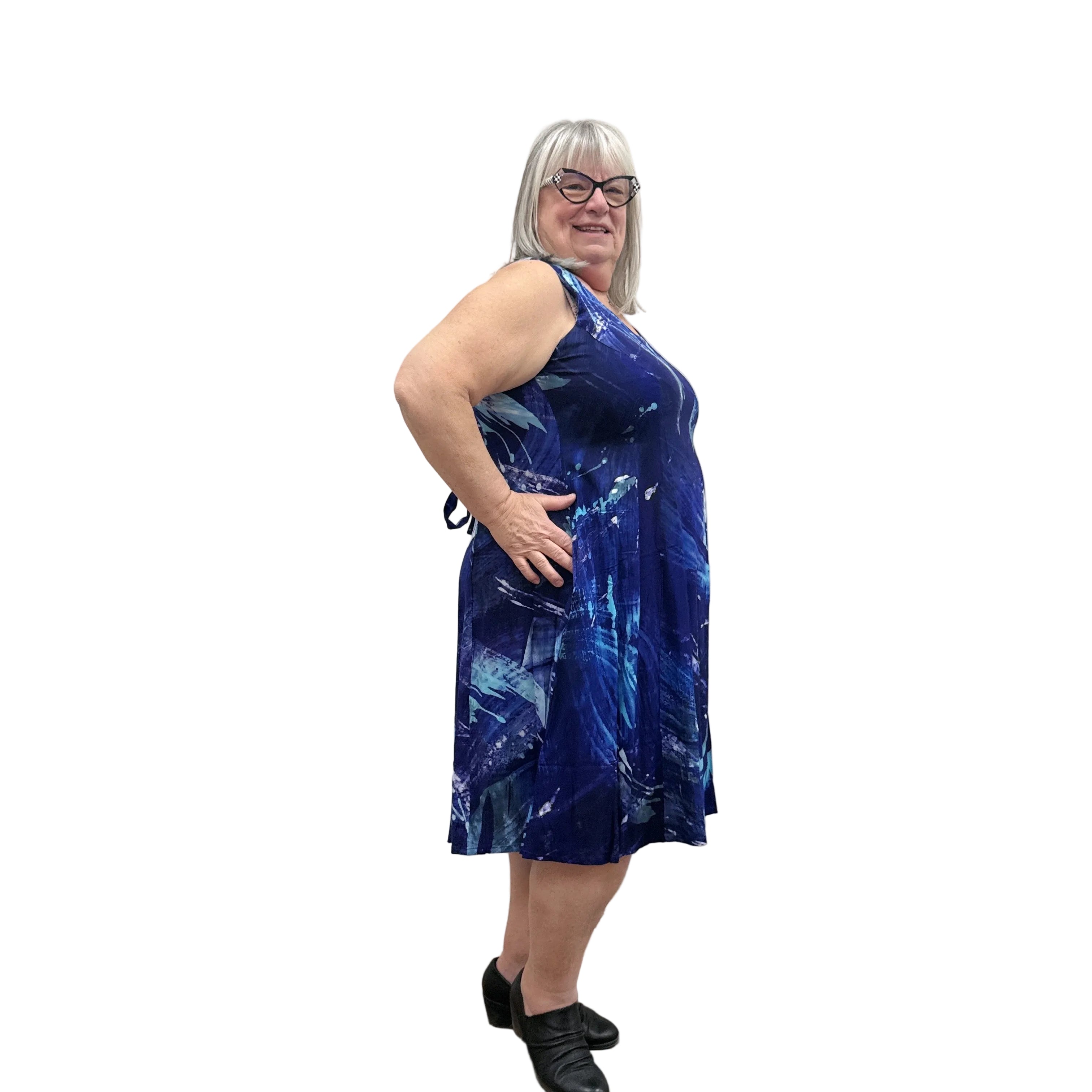 Woman wearing a blue patterned Blue Sky Sara Dress on white background.