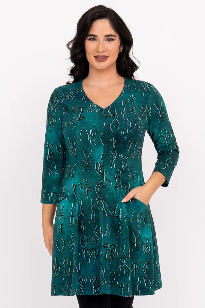 Woman wearing a teal dress with a pattern on a white background