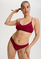 Woman wearing a red bikini against a plain background